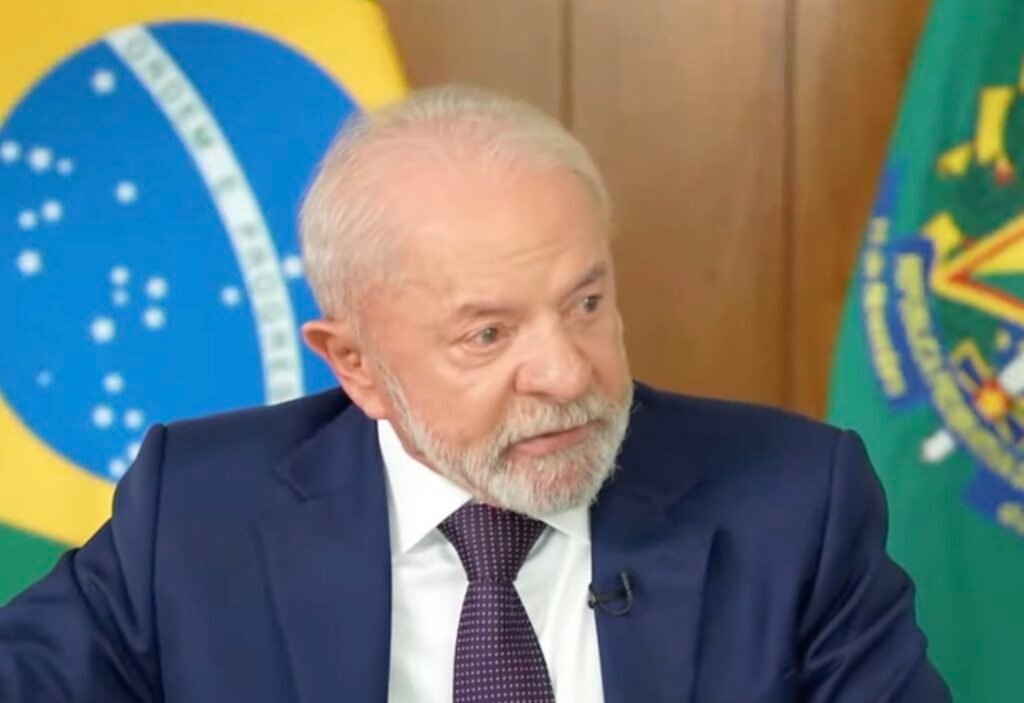 Uma frase dita sem grito, sem ataque e sem recuo abriu uma fissura num tema que quase sempre explode antes mesmo de ser entendido. O que foi dito de tão sensível assim? A afirmação foi direta: partido único não combina com a melhor prática da democracia. Parece simples, mas não é. Porque quando essa frase surge ligada a um país historicamente cercado por disputas ideológicas, ela deixa de ser apenas uma opinião e vira um teste político. Mas por que isso chama tanta atenção? Porque a fala não veio acompanhada de rompimento, nem de aplauso irrestrito. Veio num terreno mais desconfortável, aquele em que se critica um modelo e, ao mesmo tempo, se defende o direito de um povo decidir o próprio caminho. E é justamente esse ponto que faz a discussão crescer. Então houve condenação ou defesa? Nem uma coisa de forma total, nem outra de forma absoluta. A crítica foi ao modelo de partido único, tratado como algo que não condiz com a melhor prática democrática. Ao mesmo tempo, foi reafirmado o respeito à autodeterminação dos povos, com uma ideia resumida numa frase curta: cada país cuida do próprio quintal. Mas há um detalhe que quase ninguém percebe: quando alguém diz que um sistema não é o ideal, mas evita dizer que cabe a outro país impor mudanças, o debate deixa de ser apenas sobre democracia e passa a ser também sobre soberania. E aí surge a pergunta inevitável: até onde vai o direito de criticar e onde começa o dever de respeitar? A resposta apresentada foi clara. É possível discordar de um modelo político sem defender interferência externa. Esse foi o eixo da declaração. Só que isso abre outra dúvida ainda mais delicada: se há crítica ao sistema, por que manter o tom de respeito? Porque, segundo a própria fala, mudanças estruturais precisam partir dos cubanos. Esse ponto muda o peso de tudo. Em vez de sugerir pressão de fora para dentro, a ideia colocada foi a de que qualquer transformação real depende de decisão interna. E é aqui que muita gente se surpreende: a crítica não foi usada para justificar isolamento, mas para reforçar que a solução não virá por imposição. Só que a discussão não parou no campo político. O que acontece depois muda o foco e amplia o cenário. Ao comentar a situação do país, foi dito que Cuba vive sua pior crise desde a Revolução Cubana, ocorrida entre 1953 e 1959. E isso não aparece como detalhe lateral. Aparece como parte central do problema. Que crise é essa? Segundo a declaração, há escassez de alimentos, energia e insumos básicos. Ou seja, o debate sobre democracia não está solto no ar. Ele aparece ao lado de uma realidade econômica e social severa. E quando esses elementos se encontram, a leitura do caso fica ainda mais complexa. De onde viriam essas dificuldades? Parte delas foi atribuída ao embargo dos Estados Unidos. Essa menção é importante porque desloca a conversa de uma análise puramente interna para um quadro de pressão externa. Mas isso resolve a questão? Não completamente. Porque, se o embargo pesa, ainda assim permanece a pergunta sobre como o país pode buscar alternativas. Foi aí que surgiu uma nova pista. Houve a sugestão de que Cuba observe experiências de outras economias, como China e Vietnã, em busca de caminhos para recuperação. Isso significa copiar modelos? Não foi isso que se afirmou. O ponto foi indicar referências possíveis para pensar saídas, sem dizer que existe fórmula pronta. E onde entra o Brasil nessa história? Entra no envio de ajuda humanitária. Foram citados alimentos, medicamentos e sementes. Esse trecho parece menor, mas não é. Ele mostra que, ao mesmo tempo em que há crítica ao modelo político, também há reconhecimento da gravidade da crise e disposição de colaborar no plano humanitário. Só agora o quadro se fecha por completo. Quem fez essas declarações foi o presidente Luiz Inácio Lula da Silva, em entrevista concedida aos sites Brasil 247, Revista Fórum e DCM, em 14 de abril de 2026. E o centro da fala foi exatamente esse equilíbrio difícil: dizer que partido único em Cuba não condiz com a melhor prática democrática, mas sustentar que cabe aos cubanos decidir seus próprios rumos. Parece uma posição contraditória? Para alguns, sim. Para outros, é justamente aí que está a coerência. Criticar um modelo sem defender tutela externa. Reconhecer a crise sem reduzir tudo a um único fator. Oferecer ajuda sem transformar isso em ingerência. E talvez seja por isso que a frase continue reverberando: ela não encerra o debate sobre Cuba, apenas desloca a pergunta para um ponto ainda mais incômodo — como cobrar democracia sem atravessar a fronteira da autodeterminação?