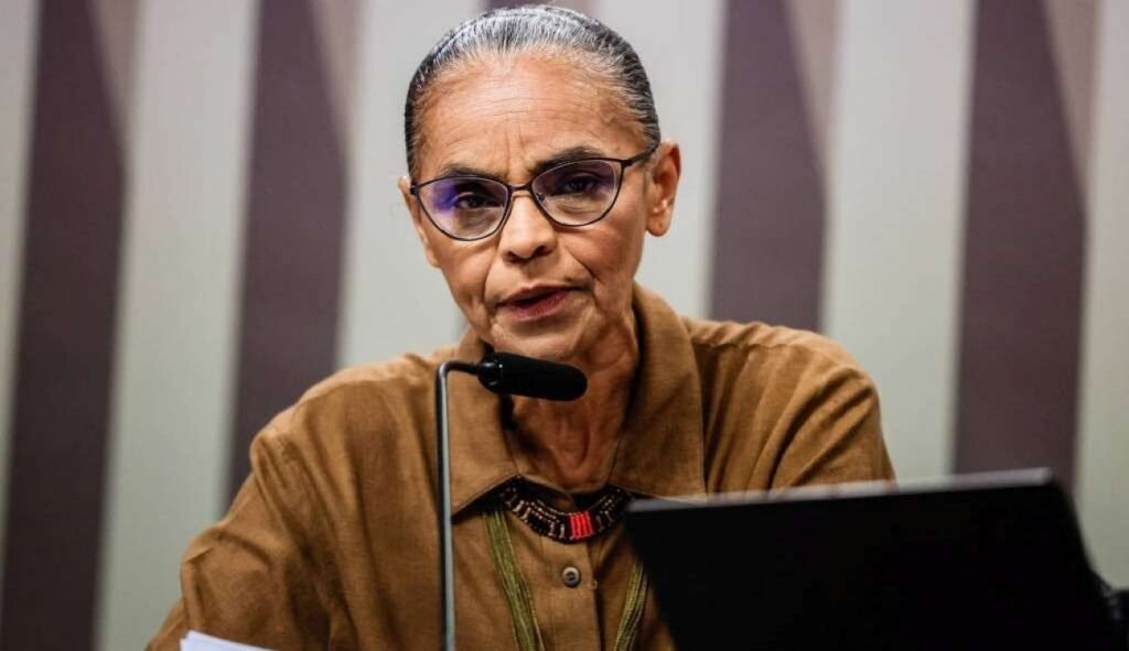 O isolamento de **Marina Silva** chegou a um ponto em que até seus antigos espaços de influência parecem ter desaparecido. O que antes ainda podia ser tratado como dificuldade política agora é descrito de forma direta: ela teria sido **literalmente abandonada**. Mas como essa situação foi se formando? Segundo o conteúdo apresentado, Marina não teria aprendido com o que ocorreu em **2014**, quando, de acordo com a descrição, foi **apunhalada pelo PT**. A lembrança desse episódio surge como uma peça importante para entender o momento atual. Em vez de reconstruir força política, o texto afirma que a ex-ministra de **Lula** entrou em um processo de **isolamento político irreversível**. E esse isolamento não aparece apenas na relação com antigos aliados. Ele também se manifesta dentro da própria estrutura partidária. No **Rede Sustentabilidade**, partido ao qual está ligada, o cenário descrito é de derrota expressiva. O texto afirma que o grupo político de Marina foi **fragorosamente derrotado**, ficando com apenas **24% de influência** dentro da legenda. Esse dado é central porque mostra que a perda de espaço não seria apenas externa, mas também interna. O que acontece quando uma liderança perde o controle até mesmo do próprio partido? A consequência, segundo a descrição, veio rapidamente. **Seus principais aliados debandaram para o PSB**. Isso amplia ainda mais a imagem de esvaziamento político. Sem esse núcleo de apoio, Marina passa a aparecer como uma figura cada vez mais sozinha no tabuleiro. E a solidão política, nesse caso, não é tratada como algo passageiro, mas como um processo já consolidado. Ao mesmo tempo, o texto diz que ela ficou **sem o convite do PT** e foi **ignorada pelos grandes caciques**. Esse ponto aprofunda a ideia de abandono. Não se trata apenas de uma disputa interna ou de uma divergência pontual. O conteúdo sugere que Marina perdeu pontes com forças que poderiam lhe oferecer sustentação em uma nova etapa eleitoral. Sem essas conexões, o caminho se estreita. Que alternativa restou? A tentativa agora, segundo o material, é buscar viabilidade para uma candidatura ao **Senado por São Paulo**. Mas essa movimentação é apresentada de forma dura: Marina estaria tentando se firmar como uma **figura solitária**. Não há, no texto, sinal de uma ampla articulação em torno desse projeto. Pelo contrário. A descrição reforça que ela chega a esse momento sem os instrumentos normalmente considerados decisivos em uma disputa eleitoral. O quadro final é resumido com uma sequência de perdas: **sem tempo de TV**, **sem o controle da própria legenda** e **sem o apoio da máquina federal**. Cada um desses elementos pesa. Juntos, formam a imagem de uma candidatura enfraquecida antes mesmo da disputa ganhar corpo. O texto afirma que, diante disso, Marina agora luta apenas para **não ser varrida do mapa eleitoral em outubro**. A construção dessa narrativa vai revelando, passo a passo, por que o título fala em abandono. Primeiro, a lembrança de 2014. Depois, o isolamento crescente. Em seguida, a derrota dentro do partido, com apenas **24% de influência**. Logo depois, a saída dos principais aliados para o **PSB**. E, por fim, a ausência de apoio do **PT**, o desprezo dos grandes líderes políticos e a tentativa de disputar o Senado em São Paulo sem estrutura relevante. O elemento central do conteúdo, de forma completa, é este: **Marina Silva parece ter sido literalmente abandonada. Ela merece. Não aprendeu nada com o que aconteceu em 2014, quando foi apunhalada pelo PT. A ex-ministra de Lula vive um isolamento político irreversível. Em seu partido, o Rede Sustentabilidade, incompetente e sem credibilidade, foi fragorosamente derrotada, ficando o seu minguado grupo político com apenas 24% de influência. Com isso, seus principais aliados debandaram para o PSB. Sem o convite do PT e ignorada pelos grandes caciques, Marina tenta se viabilizar ao Senado em São Paulo como uma figura solitária. Sem tempo de TV, sem o controle da própria legenda e sem o apoio da máquina federal, ela agora luta apenas para não ser varrida do mapa eleitoral em outubro. Será.**