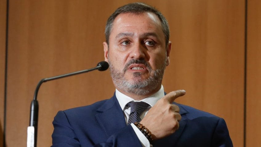 Uma viagem oficial ao exterior, paga por organizadores privados e cercada por nomes de peso, levanta uma pergunta inevitável: **quem bancou a ida do diretor-geral da Polícia Federal a Londres**? A resposta começa com um evento realizado entre **24 e 26 de abril de 2024**, na capital britânica. **Andrei Rodrigues**, diretor-geral da **Polícia Federal**, participou do **1º Fórum Jurídico – Brasil de Ideias**. Mas a dúvida sobre a viagem não ficou apenas na agenda institucional. Quem assumiu os custos dessa participação? Segundo informações obtidas via **Lei de Acesso à Informação**, a própria PF informou que os organizadores do evento arcaram com despesas de **pousada, alimentação e locomoção**. Isso significa que não houve pagamento de diárias ao servidor. Mas quem eram esses organizadores? Entre os patrocinadores do fórum estava o **Banco Master**, fundado por **Daniel Vorcaro**. Também patrocinaram o encontro a **British American Tobacco** e a **FS Security**. A partir daí, a questão ganha contorno mais preciso: o Banco Master bancou a viagem de Andrei Rodrigues para Londres. E a Polícia Federal detalhou quanto foi gasto? Não. Em resposta enviada por meio da LAI, a corporação declarou que **“não foram pagas diárias ao servidor”** porque o organizador do evento custeou diretamente as despesas extraordinárias com **pousada, alimentação e locomoção**, nos termos da legislação citada pela própria instituição. A PF acrescentou ainda que **não tinha conhecimento dos valores despendidos pelos organizadores**. Houve algum pagamento adicional ao diretor-geral? A resposta oficial foi negativa. Segundo a PF, **Andrei Rodrigues não recebeu remuneração, cachê, honorário, ajuda de custo ou qualquer outro benefício dos organizadores do evento**. Então qual foi sua participação no fórum? No dia **26 de abril**, Andrei participou do painel **“As Instituições na Defesa da Igualdade Social e Econômica”**. A presença dele, portanto, ocorreu como parte da programação do encontro jurídico. Mas onde os convidados ficaram hospedados? Os participantes ficaram no **The Peninsula London Hotel**, hotel **5 estrelas** em Londres. Em uma simulação citada na reportagem, as diárias para abril de 2026 custavam em torno de **R$ 6.000**. Ainda assim, a PF afirmou não saber os valores efetivamente gastos pelos organizadores com a viagem do diretor-geral. A história termina no fórum? Não. Londres também foi palco de outro compromisso citado na reportagem: uma **degustação de whisky Macallan** no **George Club**, clube privado localizado em **Mayfair**, uma das áreas mais caras da cidade. Quanto custou esse encontro? A degustação teve custo de **US$ 640.831,88**, cerca de **R$ 3,2 milhões** no câmbio de abril de 2024. Aproximadamente **40 pessoas** participaram da confraternização oferecida por **Daniel Vorcaro**. Quem estava entre os presentes? Além de **Andrei Rodrigues**, participaram **ministros do STF**, **ministros do STJ**, **um ministro de Estado**, o **procurador-geral da República** e **congressistas**. A reportagem informa ainda que o Poder360 procurou o diretor-geral da PF em **fevereiro de 2026** e novamente em **7 de abril de 2026** para perguntar se ele gostaria de se manifestar. Houve resposta? Até a publicação da reportagem, **não houve resposta**. O jornal informou que atualizaria o texto caso uma manifestação fosse enviada. Então, afinal, o que se sabe com clareza? Sabe-se que **Andrei Rodrigues** participou do **1º Fórum Jurídico – Brasil de Ideias**, em **Londres**, entre **24 e 26 de abril de 2024**; que a **Polícia Federal** declarou que os organizadores pagaram **pousada, alimentação e locomoção**; que **não foram pagas diárias** ao diretor-geral; que, segundo a corporação, ele **não recebeu remuneração, cachê, honorário, ajuda de custo ou qualquer outro benefício**; e que entre os patrocinadores do evento estava o **Banco Master**, que bancou a viagem do diretor-geral da PF a Londres.