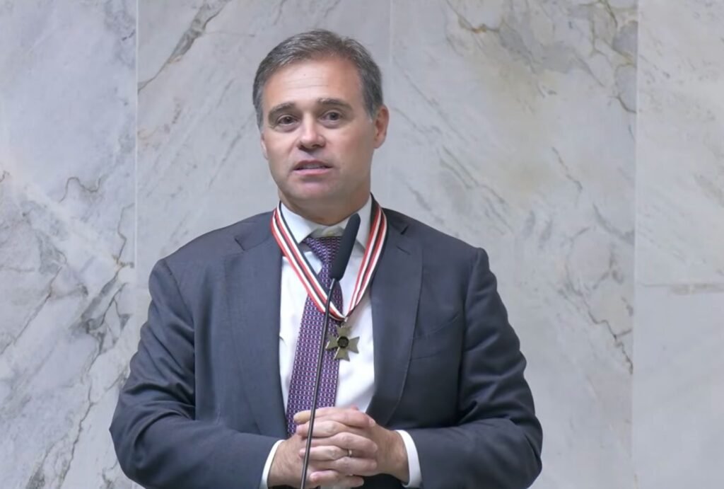 Uma frase dita em público bastou para acender uma expectativa que já circulava nos bastidores de Brasília. O ministro **André Mendonça**, do **Supremo Tribunal Federal**, afirmou que espera ver **Jorge Messias** no STF “**em breve**”. Mas em que contexto essa declaração foi feita? A fala ocorreu durante uma solenidade de entrega do **Colar da Honra ao Mérito Legislativo** na **Alesp**, realizada na segunda-feira, **6 de abril de 2026**, com a presença de Messias no evento. E o que exatamente Mendonça disse? Ao cumprimentar o ministro-chefe da **Advocacia-Geral da União**, ele declarou: “Não posso deixar de cumprimentar **Jorge Messias**, ministro-chefe da **AGU**, que muito me honra aqui presente. Faço votos que em breve você possa deixar a AGU por um bom motivo de estar ali comigo no **Supremo Tribunal Federal**”. A frase chamou atenção porque se refere diretamente à vaga aberta na Corte. Qual vaga é essa? Trata-se do posto deixado com a aposentadoria de **Luís Roberto Barroso**. Isso significa que a ida de Jorge Messias ao Supremo já está encaminhada? Não. Apesar da manifestação pública de Mendonça, **Messias ainda não tem maioria entre os senadores**, segundo mostrou o **Poder360**. Por que esse ponto importa? Porque a composição do STF depende de indicação presidencial e aprovação no Senado, o que torna o apoio político um fator decisivo. Mas o evento tratava apenas dessa possível nomeação? Também não. A homenagem a Mendonça foi proposta pelo deputado estadual **Oseias de Madureira**, do **PL**, que é pastor evangélico. Quem mais esteve presente? O governador de São Paulo, **Tarcísio de Freitas**, do **Partido Republicano**, também participou da solenidade. E houve algum traço marcante na cerimônia? Sim. A celebração contou com momentos de exibição da **fé evangélica**, em sintonia com o perfil de Mendonça, que também é pastor. Por que a presença de Mendonça nesse ambiente político e religioso ganha ainda mais peso? Porque ele ocupa hoje uma posição de destaque no Supremo. Indicado por **Jair Bolsonaro**, o ministro é relator de investigações ligadas a dois dos maiores escândalos em andamento no país. Quais casos são esses? O material menciona os casos **Master** e **INSS**, cujas decisões têm sido usadas por apoiadores de Bolsonaro para criticar **Alexandre de Moraes** e o presidente **Luiz Inácio Lula da Silva**. E quais decisões recentes de Mendonça ajudaram a ampliar essa visibilidade? O ministro determinou a prisão do ex-banqueiro **Daniel Vorcaro**. Além disso, autorizou a quebra dos sigilos bancário e fiscal de **Fábio Luís Lula da Silva**, filho do presidente Lula. Esses movimentos reforçam o peso político e institucional de suas decisões, especialmente em um momento em que qualquer fala sobre o Supremo repercute de forma imediata. Como Mendonça aparece diante da opinião pública? Uma pesquisa da **AtlasIntel**, divulgada em **20 de março**, mostra que ele é o ministro **mais bem avaliado do STF**. Quais são os números? **43%** dos eleitores disseram ter imagem **positiva** do magistrado, enquanto **36%** afirmaram ter imagem **negativa**. E como ficam outros ministros nesse levantamento? **Dias Toffoli**, **Gilmar Mendes**, **Alexandre de Moraes** e **Flávio Dino** aparecem com as piores avaliações negativas, com **81%**, **67%**, **59%** e **58%**, respectivamente. E como essa pesquisa foi feita? O estudo ouviu **2.090 pessoas** entre os dias **16 e 19 de março de 2026**. A **margem de erro** é de **2 pontos percentuais**, para mais ou para menos, com **nível de confiança de 95%**. Esses dados ajudam a entender por que uma declaração breve, feita em tom de cumprimento, ganhou dimensão política. No fim, o que ficou registrado de forma mais direta foi o desejo expresso por André Mendonça diante de Jorge Messias, em público e sem rodeios: que ele deixe a **AGU** por “**um bom motivo**” e vá “estar ali comigo no **Supremo Tribunal Federal**”.