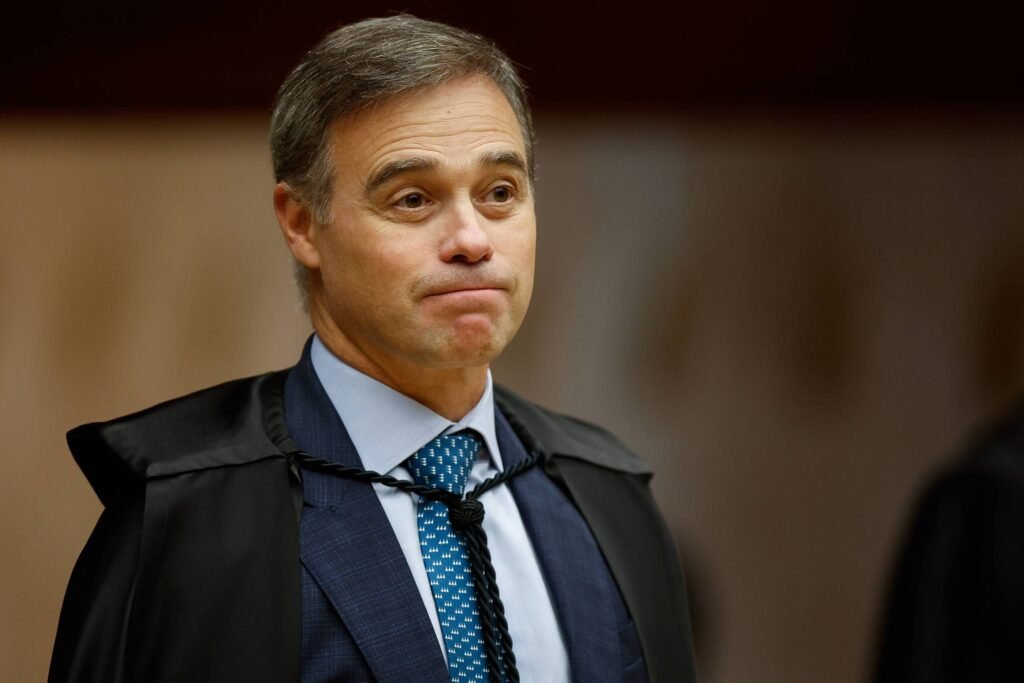 Por que André Mendonça fragmenta investigações de grande porte? Mendonça fragmenta investigações para evitar vazamentos e interferências, mantendo informações compartimentadas entre os investigadores. Como a fragmentação das investigações ajuda a evitar vazamentos? A divisão impede que advogados e superiores tenham acesso a informações de outros alvos, reduzindo o risco de vazamentos. Qual é a experiência de Mendonça que influencia essa estratégia? Antes de ser ministro do STF, Mendonça liderou o Ministério da Justiça e a AGU, lidando com informações sensíveis e criando laboratórios de análise de dados sigilosos. Quem auxilia Mendonça em casos criminais? Desde outubro, um delegado da Polícia Federal emprestado ao gabinete de Mendonça auxilia em casos criminais e dá sugestões sobre os trabalhos. Como a estratégia de Mendonça afeta a Polícia Federal? A estratégia visa preservar as investigações e a própria PF, organizando os procedimentos e dando maior independência aos investigadores. Quais são as principais investigações sob a relatoria de Mendonça? Mendonça é relator do caso das suspeitas de fraudes no INSS e do caso Banco Master, que envolve tentativas de compra e fraudes financeiras. Como Mendonça lida com a cúpula da PF nas investigações? Ele proibiu que a cúpula da PF e superiores aos delegados do caso Banco Master tenham acesso aos inquéritos, reduzindo riscos de interferências. Qual é a dinâmica das investigações do caso Banco Master? As investigações são divididas entre diferentes estados, com delegados distintos, e coordenadas por um delegado designado pela direção da PF. Quais são os desdobramentos do caso Banco Master? Além dos quatro inquéritos principais, há investigações no Rio de Janeiro sobre supostos crimes contra o sistema financeiro envolvendo o Rioprevidência. Por que a atuação de Mendonça é criticada por advogados? Advogados reclamam que pedidos ficam sem apreciação ou retidos no gabinete de Mendonça, sem serem enviados à PGR para manifestação. Como Mendonça responde a vazamentos de informações? Ele já instaurou investigações sobre vazamentos, como no caso de mensagens do celular do ex-dono do banco compartilhadas com a CPI do INSS. Qual é a relação de Roberta Luchsinger com as investigações? Roberta Luchsinger, amiga de Lulinha, é investigada no caso do INSS e sua defesa pediu investigações sobre vazamentos de informações à imprensa. Como Mendonça garante o sigilo nas investigações? Ele afirma que apenas autoridades policiais e agentes diretamente envolvidos devem ter conhecimento das informações, impondo o dever de sigilo profissional. Qual é o impacto da fragmentação nas investigações do INSS? A investigação do INSS é ainda mais pulverizada devido aos diversos focos ligados às associações que atuavam no esquema. Como Mendonça define a dinâmica das investigações? Ele realizou encontros com equipes responsáveis para apresentar e definir a dinâmica preferida, acompanhando o andamento dos casos. Quais são as fases da Operação Compliance Zero? A primeira fase prendeu o banqueiro Daniel Vorcaro em Brasília, enquanto a segunda fase, em São Paulo, investiga fraudes por meio de fundos de investimento. Como a fragmentação afeta a defesa dos investigados? A divisão das apurações impede que a defesa de um investigado acesse informações de outros alvos, dificultando a estratégia de defesa. Qual é a importância da experiência de Mendonça na AGU? Na AGU, Mendonça criou um laboratório de análise de dados sigilosos e coordenou equipes de acordos de leniência, experiências que influenciam sua atuação no STF. Como Mendonça organiza as investigações? Ele designa coordenadores para as apurações, mas mantém as informações compartimentadas entre os investigadores para evitar vazamentos. Qual é a visão de Mendonça sobre a preservação do sigilo? Mendonça acredita que a preservação do sigilo e da funcionalidade das investigações é essencial para o sucesso dos inquéritos.