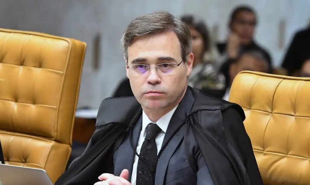 Uma decisão travou o acesso a informações que poderiam mudar o rumo de uma CPI — e o motivo disso levanta mais perguntas do que respostas. Que decisão foi essa? O ministro André Mendonça, do Supremo Tribunal Federal, negou dois pedidos feitos pela CPI do Crime Organizado, no Senado, para compartilhar dados de investigações que envolvem o Banco Master e a morte de Luiz Phillipi Machado de Moraes Mourão, conhecido como “Sicário”. Mas por que barrar esse acesso agora? Segundo o ministro, as apurações ainda estão em andamento. As informações reunidas na Operação Compliance Zero e nas investigações sobre fraudes ligadas ao Master, que estão sob sua relatoria no Supremo, ainda dependem de diligências pendentes. E quando uma investigação não terminou, o que pode acontecer se esse material for liberado antes da hora? É justamente aí que surge o ponto mais sensível. Mendonça afirma que divulgar esses dados neste momento poderia comprometer o trabalho em curso. Em outras palavras, o compartilhamento com a CPI, agora, poderia interferir na fase de apuração. Mas isso significa um bloqueio definitivo? Não. E é aqui que muita gente se surpreende. A negativa não fecha a porta para sempre. O ministro deixou aberta a possibilidade de reavaliar o pedido no futuro, quando a fase de investigação estiver concluída. Se existe essa possibilidade, então por que o caso chamou tanta atenção? Porque os pedidos não tratavam de um tema qualquer. Eles foram apresentados pelo senador Alessandro Vieira e aprovados pela CPI em 11 de março. A comissão queria entender se a morte de Felipe Mourão poderia indicar um comportamento típico de organização criminosa, daquele tipo em que a morte seria preferível à condenação ou à colaboração com autoridades. Mas há um detalhe que quase ninguém percebe: a CPI também queria avaliar como esse tipo de conduta poderia ser evitado em ambientes policiais e prisionais, que têm o dever de preservar a integridade física e mental de quem está sob custódia. E o que aconteceu com Mourão para esse debate ganhar tanta força? Ele foi preso pela Polícia Federal em 4 de março e, no mesmo dia, tentou suicídio enquanto estava sob custódia em Minas Gerais. Foi levado ao hospital, mas não resistiu. A morte foi confirmada oficialmente no dia 6 e registrada em cartório. O velório ocorreu no dia 8. Mas por que esse nome, em especial, passou a ocupar um espaço tão central? Porque Mourão não era tratado como um personagem secundário. Ele era apontado como um dos homens de confiança do banqueiro Daniel Vorcaro. O apelido “Sicário”, segundo a própria Polícia Federal, era compatível com as atividades que ele exercia para o dono do Banco Master. E o que exatamente ele fazia? De acordo com a PF, Mourão seria responsável por obter informações sigilosas, monitorar adversários e neutralizar situações consideradas sensíveis aos interesses do banqueiro. O que acontece depois muda tudo: embora o apelido sugira algo ainda mais extremo, a própria investigação afirma que ele não chegou a cometer assassinatos. Então por que o nome pesa tanto? Porque, segundo a Polícia Federal, ele integrava o núcleo de intimidação e obstrução à Justiça. Esse grupo teria sido batizado de “A Turma” em um grupo de WhatsApp encontrado no celular de Vorcaro. E isso abre outra frente ainda mais delicada: Mourão é acusado de obter informações sigilosas por meio de acesso indevido a sistemas da PF, do Ministério Público Federal, do FBI e da Interpol. Mas se o caso é tão grave, por que a CPI não pode ver tudo agora? Porque, na avaliação de Mendonça, o estágio atual das investigações exige cautela. E esse ponto ganha ainda mais peso porque o julgamento foi suspenso após pedido de vista do ministro Flávio Dino. Ou seja: o tema não desapareceu, apenas entrou em compasso de espera. No fim, o que está em jogo não é só o acesso a documentos. É a disputa entre a urgência política de uma CPI e o tempo próprio de uma investigação judicial ainda aberta. Mendonça negou o compartilhamento agora, mas deixou uma fresta para o futuro. E é justamente nessa fresta que permanece a pergunta que ainda não foi encerrada: quando essas informações vierem à tona, o que elas realmente vão revelar sobre a morte do “Sicário” e sobre tudo o que ainda está por trás dela?