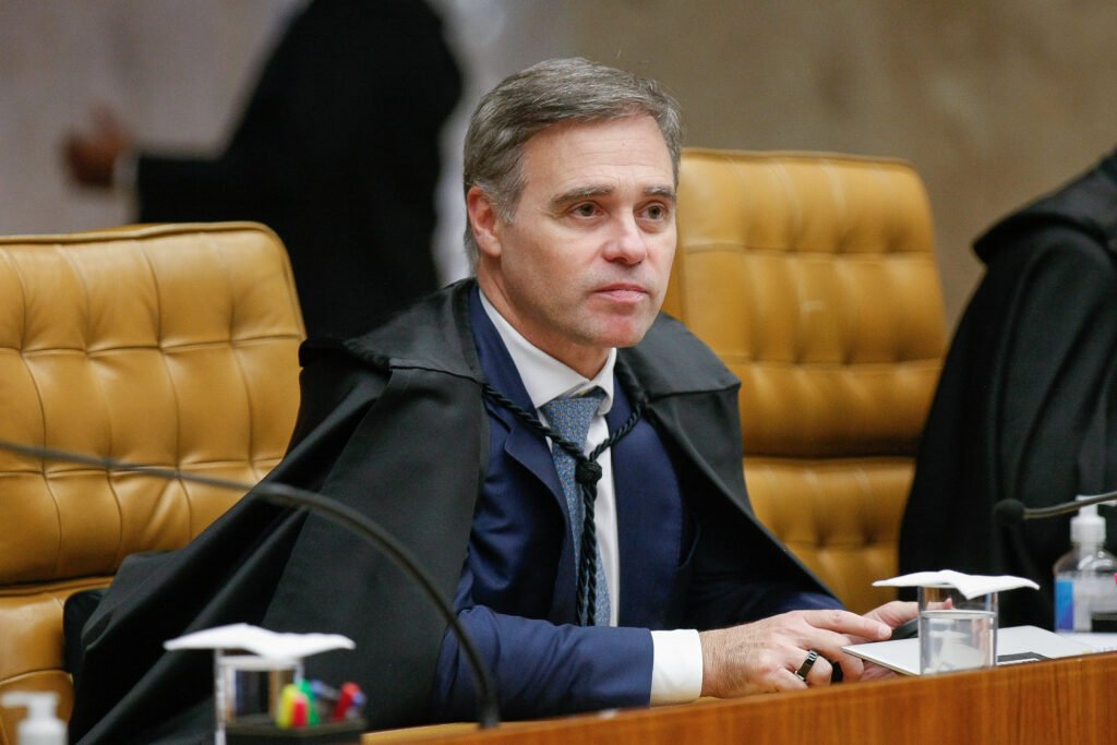 Uma disputa que começou com palavras nas redes sociais agora chega às mãos de um ministro do **Supremo Tribunal Federal**. Quem vai conduzir esse caso? O ministro **André Mendonça** foi sorteado, nesta terça-feira, dia 7, para ser o relator da **queixa-crime** apresentada pelo ex-presidente **Jair Bolsonaro** contra o deputado federal **André Janones**. Mas por que essa ação foi apresentada? A iniciativa partiu da defesa de Bolsonaro, que protocolou a queixa-crime na segunda-feira, dia 6. O motivo está em declarações feitas por Janones nas redes sociais, em que o parlamentar questionou a concessão de **prisão domiciliar** a Bolsonaro e fez acusações diretas contra ele. O que exatamente foi dito? Na gravação compartilhada entre os dias 25 e 28 de março, Janones chamou Bolsonaro de **“ladrão”** e afirmou: “Esse vagabundo, ladrão que mandou matar o Lula, mandou matar o Alckmin, esse safado está indo para casa para articular contra o fim da escala 6x1. É isso que ele quer para poder articular com o [Donald] Trump, para ferrar com o povo brasileiro e principalmente para fazer você continuar trabalhando igual um condenado”. E por que a defesa de Bolsonaro decidiu levar o caso à Justiça criminal? Porque sustenta que as falas atribuídas a Janones configuram **calúnia**, **difamação** e **injúria**. Além disso, os advogados argumentam que houve ampla divulgação das declarações nas redes sociais, o que, segundo a queixa, justificaria **aumento de pena** e também a fixação de um valor mínimo para **reparação por danos morais**. A discussão envolve também a **imunidade parlamentar**? Sim. A defesa de Bolsonaro afirma que, neste caso, essa proteção não deveria ser aplicada. Qual é o argumento? Segundo os advogados, as ofensas teriam caráter **“personalíssimo”** e não manteriam conexão direta com o exercício do mandato legislativo de Janones. O que acontece a partir da definição do relator? Com o sorteio, caberá a **André Mendonça** conduzir a tramitação da queixa-crime no STF. Isso significa que ele será o ministro responsável por analisar os próximos passos do processo apresentado por Bolsonaro contra Janones. E qual é, afinal, o ponto central dessa movimentação? A ação protocolada pela defesa do ex-presidente pede a condenação de **André Janones** pelos supostos crimes de **calúnia**, **difamação** e **injúria**, com pedido de **aumento de pena** pela divulgação nas redes sociais e de fixação de valor mínimo para **danos morais**, e terá como relator no **STF** o ministro **André Mendonça**.