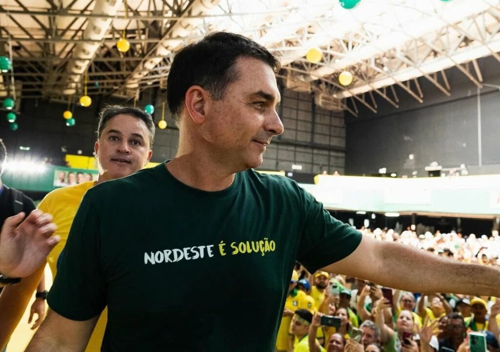 Em apenas seis meses, um movimento silencioso nas redes mudou o tamanho de uma disputa que muita gente ainda nem percebeu por completo. Mas o que realmente cresceu tanto assim? Não foi um detalhe pequeno, nem uma oscilação comum de plataforma. O salto foi de 12 milhões para 16,6 milhões de seguidores, uma alta de 38,1% em um intervalo relativamente curto. E quando um número desse tamanho aparece, a pergunta surge quase sozinha: isso aconteceu de forma espalhada ou houve momentos específicos que aceleraram tudo? Houve, sim, pontos de virada. E é justamente aí que a maioria se surpreende. O avanço não foi apenas constante, como se tivesse vindo de um crescimento orgânico uniforme ao longo dos meses. Dois episódios em dezembro concentraram picos importantes de novos seguidores. Então por que dezembro virou esse ponto de inflexão? Porque foi nesse mês que aconteceram dois fatos diretamente ligados à explosão da base. No dia 5, veio o anúncio da pré-candidatura à Presidência. No dia 17, houve o apoio público de Pablo Marçal. Esses dois momentos funcionaram como gatilhos de visibilidade e atração de público. Mas há um detalhe que quase ninguém percebe: crescer rápido em seguidores não significa automaticamente liderar o jogo digital por completo. Então esse avanço já colocou esse nome no topo das redes? Ainda não. Apesar da alta expressiva, o total continua abaixo do presidente Luiz Inácio Lula da Silva. E isso muda a leitura dos números, porque mostra que uma expansão acelerada pode impressionar muito, mas ainda convive com uma diferença relevante de base acumulada. Só que, se o total ainda não é o maior, onde está o sinal mais forte dessa mudança? Está no contraste entre tamanho e reação do público. Lula teve crescimento mais modesto no mesmo período: 3,9%. Sua base passou de 29,6 milhões para 30,8 milhões de seguidores. É uma alta menor, mas sobre um universo muito maior. Isso levanta outra dúvida inevitável: se um tem mais seguidores totais, por que o outro chama tanta atenção agora? Porque o debate não para no número bruto. O que acontece depois muda tudo. Entre janeiro e fevereiro de 2026, o senador somou cerca de 50 milhões de interações nas publicações. No mesmo recorte, Lula registrou 28,2 milhões. E é aqui que o cenário ganha outra camada: não se trata apenas de quantas pessoas seguem, mas de quantas reagem, comentam, compartilham e mantêm o conteúdo em circulação. Mas esse desempenho veio de uma rede específica ou do conjunto? O levantamento considera Facebook, Instagram e X somados. Isso importa porque evita a leitura isolada de uma única plataforma e mostra um crescimento distribuído na presença digital. Ainda assim, a pergunta que fica no ar é talvez a mais importante de todas: o que esses números realmente sinalizam? Eles sinalizam que houve uma aceleração clara de presença e resposta do público em torno de um nome que entrou em nova fase política desde outubro de 2025. E, quando essa aceleração coincide com anúncio de pré-candidatura e apoio público de uma figura com alcance digital, o efeito deixa de parecer casual. Só que existe outra nuance que mantém tudo em aberto: avanço rápido não elimina a distância para quem já largou com uma base muito maior. Então qual é o ponto principal por trás desses dados? Que Flávio Bolsonaro foi quem mais ganhou tração proporcional nas redes nesse período, saltando 38,1% em seis meses, impulsionado especialmente por dois episódios de dezembro, e ainda conseguiu superar Lula em engajamento recente, mesmo permanecendo atrás em seguidores totais. Esse é o dado que reorganiza a conversa. Porque, quando alguém cresce menos em volume total, mas mais em velocidade e reação do público, a disputa deixa de ser apenas sobre quem é maior agora e passa a ser sobre quem está conseguindo mover mais gente no presente. E talvez seja justamente aí que a história ainda não terminou.