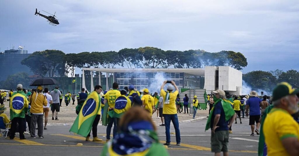 Mais de 40 séculos de prisão por um único episódio: como um dia de caos conseguiu produzir uma soma de penas que atravessa gerações inteiras? A pergunta parece exagerada, mas os números divulgados pelo Supremo Tribunal Federal não deixam muito espaço para dúvida. O balanço da Corte mostra que 806 pessoas foram condenadas pela participação na invasão e depredação de prédios públicos na Praça dos Três Poderes, em 8 de janeiro de 2023. E isso não é tudo. Além desse grupo, outras 29 pessoas foram apontadas como líderes e organizadores da ação que, segundo a acusação, buscava criar as condições para um golpe de Estado. Somadas, as penas ultrapassam 4.000 anos de prisão. Mas como esse total chegou a um patamar tão impressionante? A resposta está no volume de condenações e no peso atribuído aos diferentes níveis de participação. Não se trata de uma única sentença monumental, e sim de centenas de decisões que, reunidas, formam um retrato duro da resposta judicial ao 8 de janeiro. Só que há um detalhe que quase ninguém percebe: dentro desse total gigantesco, existe um núcleo que concentrou as punições mais severas. Quem são os réus que receberam as maiores penas? É aqui que muita gente se surpreende. Entre os 29 condenados apontados pela Procuradoria-Geral da República como integrantes dos quatro núcleos responsáveis por organizar e executar a tentativa de sublevação, estão os nomes que receberam as sentenças mais pesadas. Segundo o levantamento, esse grupo foi tratado de forma distinta justamente por ter sido considerado peça central na articulação da trama. E qual foi a maior pena aplicada? O ponto mais simbólico aparece justamente aí. Apontado como líder da organização criminosa, o ex-presidente Jair Bolsonaro foi condenado a 27 anos e três meses de prisão. Ele foi acusado por cinco crimes: golpe de Estado, tentativa de abolição violenta do Estado Democrático de Direito, organização criminosa armada, dano qualificado e deterioração de patrimônio tombado. Preso há 50 dias, ele está em uma sala-cela da Superintendência da Polícia Federal, em Brasília. Mas a história para nele? Nem de longe. O que acontece depois muda a dimensão do caso. Logo atrás de Bolsonaro aparece o general Mário Fernandes, condenado a 26 anos e seis meses de prisão. Segundo a descrição do caso, ele foi autor de um plano que tinha como objetivo assassinar o presidente recém-eleito Luiz Inácio Lula da Silva, o vice Geraldo Alckmin e o ministro do STF Alexandre de Moraes, relator dos processos sobre a tentativa de golpe na Corte. Então todos os 29 réus desse núcleo foram condenados da mesma forma? Não. E esse é outro ponto que ajuda a entender o tamanho e a complexidade do julgamento. Entre setembro e dezembro do ano passado, o STF realizou 21 julgamentos para analisar a participação dos integrantes desses quatro núcleos. Dos 29 réus, 25 receberam condenações integrais, dois tiveram condenações parciais e outros dois foram absolvidos das imputações. As penas, nesse grupo, variaram de 14 a 27 anos de prisão. Mas por que esse recorte importa tanto, se o número total já é tão alto? Porque ele mostra que o tribunal separou os participantes conforme o papel atribuído a cada um. De um lado, centenas de condenados pela invasão e depredação. De outro, um grupo menor, tratado como responsável por organizar e impulsionar a tentativa de ruptura institucional. E é justamente nessa divisão que o caso ganha outro peso político e jurídico. Ainda assim, a pergunta que fica é inevitável: o que significa, na prática, falar em 40 séculos de prisão? Significa que o 8 de janeiro deixou de ser apenas a imagem de prédios depredados e passou a ser traduzido em uma resposta penal de escala histórica. Não por uma única decisão isolada, mas por um conjunto de condenações que o STF consolidou como resposta à invasão, à destruição e à trama descrita como golpista. E o ponto principal aparece no fim, quase como um choque tardio: o número que mais chama atenção não é apenas o de 4.000 anos somados, mas o fato de que a maior pena recaiu sobre o nome apontado como líder da articulação. Só que há algo que continua em aberto no debate público: quando uma soma de penas alcança 40 séculos, ela não encerra a história — ela apenas redefine o tamanho dela.