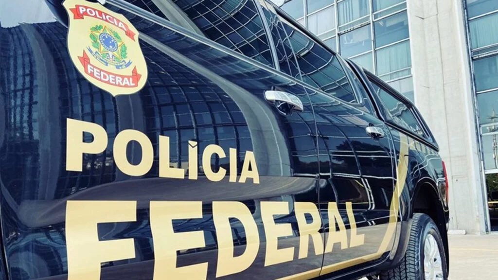 Uma operação da **Polícia Federal** abriu caminho para rastrear um rombo cercado por imóveis, empresas em nome de terceiros e suspeitas de **lavagem de dinheiro**. O que levou a essa ofensiva? Segundo a apuração divulgada, a PF deflagrou, nesta quarta-feira, 8, uma ação para investigar suspeitas de **fraudes financeiras** em uma **entidade de previdência complementar** vinculada a uma estatal de **Santa Catarina**. Mas a investigação ficou apenas no campo da apuração? Não. A ação atingiu diretamente o patrimônio dos investigados. Por determinação da **Justiça**, houve o **sequestro de mais de 30 imóveis** e o **bloqueio de valores de até R$ 365 milhões**. Para que servem essas medidas? Elas buscam garantir eventual **ressarcimento** diante dos prejuízos já identificados. E que tipo de prejuízo está no centro do caso? Os investigadores apontam que a entidade teria direcionado recursos para **investimentos de alto risco**, sem **garantia econômica adequada**. Por que isso chama tanta atenção? Porque parte dessas aplicações foi considerada **irrecuperável**, o que amplia a gravidade das suspeitas e reforça a necessidade de preservar bens e valores enquanto o caso avança. Quem aparece como foco principal dessa apuração? A PF identificou um **ex-diretor financeiro** como o principal alvo. Qual seria o papel dele? De acordo com as investigações, ele integraria o grupo responsável pelas decisões que resultaram nas irregularidades. Isso significa que a suspeita não se limita a um erro isolado? Exatamente. A linha investigativa indica a atuação de um grupo envolvido nas decisões que levaram ao desvio do padrão esperado para a gestão dos recursos. E o que esse grupo buscaria com essas decisões? Conforme a apuração, o esquema teria como objetivo obter **vantagem econômica indevida**. O que teria acontecido depois? Ainda segundo os investigadores, os valores teriam sido posteriormente ocultados, o que levou a investigação a avançar também sobre a forma como os recursos circularam e sobre os bens adquiridos ao longo desse processo. Como esse dinheiro teria sido movimentado? As investigações mostram que os suspeitos usaram **empresas registradas em nome de terceiros** para movimentar recursos. Por que isso é relevante? Porque esse tipo de estrutura pode dificultar a identificação dos verdadeiros beneficiários e esconder a origem ou o destino do dinheiro. E houve aquisição de patrimônio por esse caminho? Sim. De acordo com a PF, o grupo também teria comprado bens por meio dessa mesma estrutura. Que bens entraram no radar? **Diversos imóveis**. O que chamou a atenção nesses negócios? Segundo a Polícia Federal, vários desses imóveis foram comprados **sem comprovação formal de pagamento**. Por que esse detalhe pesa tanto? Porque, na avaliação dos investigadores, esse padrão é **compatível com práticas de lavagem de dinheiro**. A operação, então, mira apenas pessoas ou também tenta recuperar valores? As duas frentes aparecem juntas. De um lado, a investigação busca esclarecer as responsabilidades pelas decisões e pela movimentação dos recursos. De outro, as medidas patrimoniais tentam preservar ativos para um possível retorno financeiro diante das perdas apontadas. E qual é o quadro que emerge até aqui? Uma investigação sobre suspeitas de **fraudes financeiras** em uma entidade de previdência complementar ligada a uma estatal catarinense, com foco em aplicações de **alto risco**, parte delas tida como **irrecuperável**, e em um suposto esquema de ocultação de valores por meio de **empresas em nome de terceiros** e compra de **imóveis sem comprovação formal de pagamento**. No centro das medidas já executadas estão o **sequestro de mais de 30 imóveis** e o **bloqueio de até R$ 365 milhões**, enquanto a PF aponta um **ex-diretor financeiro** como principal alvo da operação.