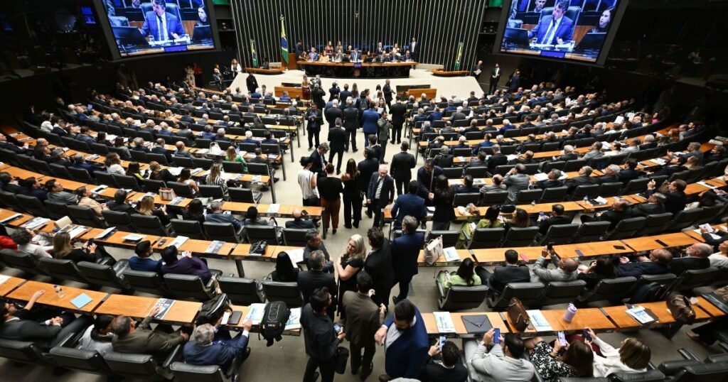 Uma mudança aprovada na Câmara pode alterar de forma decisiva o acesso de milhares de pescadores artesanais ao **seguro-defeso**. O que exatamente foi decidido? O plenário da **Câmara dos Deputados** aprovou, nesta terça-feira (7), novas regras para o benefício pago durante o período em que a pesca fica proibida. E o que acontece agora? O texto segue para análise do **Senado**. De onde veio essa proposta? A base da medida é a **MP 1323/25**, que já havia sido aprovada anteriormente pela comissão mista do Congresso. Quem conduziu esse texto? O relatório foi elaborado pelo senador **Beto Faro (PT-PA)**, enquanto o deputado **Sidney Leite (PSD-AM)** atuou como relator revisor e conduziu a matéria na Câmara. Mas o que mudou de fato no benefício? A resposta está no esforço de manter controles contra fraudes sem impedir o acesso de quem depende do pagamento. Quais mecanismos de controle foram mantidos? O texto preserva medidas propostas pelo governo, como o **cruzamento de dados** e as exigências de **validação cadastral**. Por que isso ganhou tanto peso na discussão? Porque a medida provisória foi editada justamente para reforçar o controle sobre o seguro-defeso diante do aumento das despesas e do número de beneficiários. Isso significa regras mais duras para todos? Não exatamente. Ao mesmo tempo em que mantém instrumentos de fiscalização, a proposta aprovada traz mudanças para **flexibilizar exigências** e facilitar o acesso ao benefício. Como essa flexibilização vai funcionar? Uma das mudanças permite que o cadastro no **CadÚnico** seja regularizado depois da concessão do benefício. E a **coleta biométrica**? Ela também poderá ser feita posteriormente, dependendo das condições de acesso enfrentadas pelos pescadores. Por que isso importa? Porque muitos trabalhadores vivem em áreas remotas, onde o atendimento presencial e a estrutura necessária nem sempre estão disponíveis no momento exigido. E como alcançar essas regiões mais distantes? O texto autoriza o uso de **meios alternativos de atendimento**, como **unidades móveis** e o apoio de entidades representativas, entre elas **colônias** e **associações**. O que isso busca resolver? A dificuldade de acesso ao programa em locais onde a presença do poder público é limitada. Em vez de concentrar todo o processo em estruturas fixas, a proposta abre espaço para ampliar o alcance do atendimento. Há mudança também no pagamento? Sim. O texto estabelece prazo de até **60 dias** para o repasse após a comprovação do direito ao benefício. Isso vale apenas para novos pagamentos? Não. A regra inclui também **valores atrasados de anos anteriores**. O que essa previsão faz? Dá uma referência objetiva para o repasse, depois que o direito do pescador for comprovado. E na área fiscal, o que foi definido? A proposta fixa um teto de **R$ 7,9 bilhões** para o pagamento da União aos pescadores em **2026**. Esse limite atinge tudo? Não. O texto exclui do teto as despesas referentes a **passivos**, evitando impacto sobre novos beneficiários. Por que essa separação foi incluída? Para que débitos acumulados não comprometam os pagamentos relacionados aos pedidos correntes. As exigências para comprovar a atividade pesqueira também mudaram? Sim. O projeto altera essas regras ao substituir exigências consideradas excessivas por critérios mais compatíveis com a realidade da **pesca artesanal**. O que isso significa na prática? Que a comprovação da atividade passa a seguir parâmetros vistos como mais adequados ao cotidiano dos pescadores artesanais, sem manter cobranças apontadas como desproporcionais. E há algum efeito além do seguro-defeso? Sim. A proposta amplia o acesso ao **crédito** para pescadores ao permitir enquadramento em condições semelhantes às do **Pronaf**, o Programa Nacional de Fortalecimento da Agricultura Familiar. Por que esse ponto aparece junto das novas regras? Porque a tramitação da medida acabou reunindo ajustes ligados não só ao benefício, mas também às condições de apoio a essa atividade. Qual foi o centro do debate durante a tramitação? O equilíbrio entre o **combate a fraudes** e a **garantia de acesso ao benefício**. E como esse equilíbrio foi desenhado no texto aprovado? Com a manutenção de controles, como cruzamento de dados e validação cadastral, ao mesmo tempo em que se permite regularizar o **CadÚnico** depois da concessão, realizar a **biometria** posteriormente, usar **unidades móveis** e apoio de **colônias** e **associações**, garantir pagamento em até **60 dias** após a comprovação do direito, incluir **atrasados**, fixar teto de **R$ 7,9 bilhões em 2026**, excluir **passivos** desse limite, ajustar a comprovação da atividade pesqueira e ampliar o acesso ao crédito em condições semelhantes às do **Pronaf**.