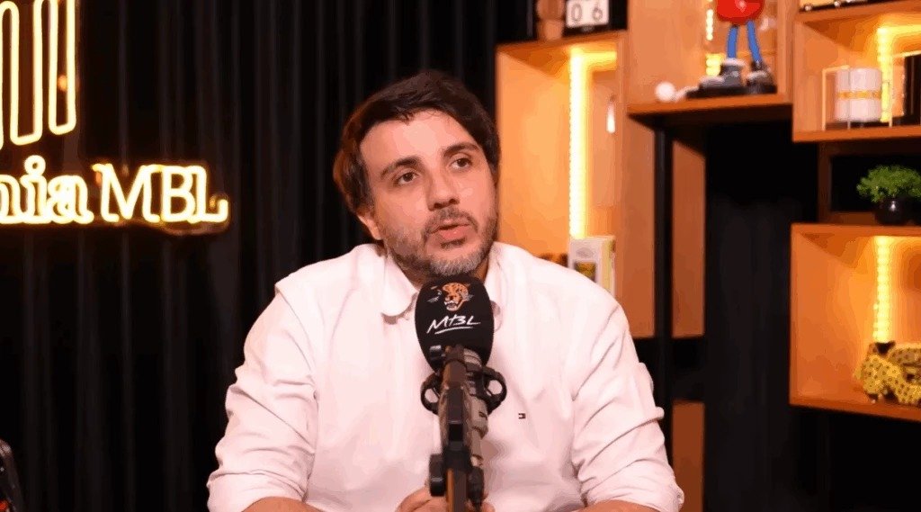 Bastou uma frase curta, quase casual, para acender uma crise difícil de conter. Mas por que uma mensagem privada teria força para virar notícia? Porque ela não traz apenas um relato pessoal. Ela encosta diretamente em um ponto sensível: a distância entre o que se diz em público e o que se admite em reservado. E quando essa distância aparece por escrito, a reação costuma ser imediata. O que exatamente foi dito? Em uma conversa vazada, o pré-candidato à Presidência e fundador do MBL, Renan Santos, afirmou ter usado cogumelos. Em uma das mensagens, escreveu: “Cara. Tomei um cogumelo e tô ouvindo Wagner. Adeus”. A referência era ao compositor alemão Richard Wagner. Só isso já seria suficiente para gerar repercussão? Não completamente. Então o que ampliou o impacto? O fato de não ter sido um episódio isolado nas mensagens reveladas. Duas semanas depois, ele voltou ao tema e relatou novo uso. Disse que havia usado cogumelo novamente no fim de semana e afirmou ter certeza de que existe “um mundo gigante cheio de significados no inconsciente”, acrescentando que se tratava do “cubensis”, substância popularmente conhecida como Cogumelo Mágico. Mas há um detalhe que quase ninguém percebe de imediato: o centro da controvérsia não está apenas no uso relatado, e sim no contraste com o discurso público adotado contra o uso e o tráfico de drogas. É justamente aí que a história deixa de ser apenas uma conversa vazada e passa a ter peso político. E como essas mensagens vieram à tona? Elas foram reveladas pelo colunista Demétrio Vecchioli, do portal Metrópoles, na quinta-feira, dia 9. A partir daí, surgiu a pergunta inevitável: ele negou o conteúdo? Não. Renan confirmou a veracidade das informações e tentou justificá-las. Qual foi a explicação apresentada? Ele afirmou que foi adicionado ao grupo Cannipapo em setembro de 2024 sem sua anuência. Depois de perceber que se tratava de uma reunião de apoiadores, decidiu permanecer no grupo. Essa versão resolve a questão? Não exatamente, porque o foco deixou de ser a entrada no grupo e passou a ser o teor das mensagens enviadas por ele dentro desse espaço. E é aqui que muita gente se surpreende: ao tentar se defender, Renan apresentou uma justificativa que abriu novas dúvidas. Disse que ganhou o entorpecente e que tomou microdoses. Até aí, a linha era de minimizar o episódio. O problema é que, ao falar sobre quantas vezes usou a substância, ele se contradisse. Como assim? Em sua resposta, afirmou em um momento que tomou “uma vez” e, em outro, declarou que, “que eu me lembro”, tomou “três vezes” na vida. Também mencionou a possibilidade de ter usado microdosagem para trabalhar, para escrever e para ver artigos, mas disse não se lembrar com clareza. Essa oscilação enfraqueceu a tentativa de encerrar o assunto rapidamente. O que acontece depois muda tudo, porque a defesa deixa de ser apenas factual e passa a ser política. Renan afirmou que nunca comprou, que nunca financiou tráfico internacional e que não é “um drogado”. Também disse que não recomenda que outros façam o mesmo e garantiu que não voltará a usar caso sua base eleitoral seja contrária. Mas isso elimina a contradição apontada? Para ele, não. Em sua justificativa, sustentou que isso não compromete sua postura como homem público nem sua defesa do que considera importante. Só que essa resposta não fecha a discussão. Pelo contrário, abre outra: até que ponto o eleitor aceita separar comportamento privado de discurso público quando os dois parecem colidir? Há ainda um ponto objetivo no meio de toda essa polêmica. O cultivo, a compra e a comercialização da substância só são permitidos em casos de pesquisa, coleção e amostra botânica. Isso não encerra o debate, mas recoloca a história em um terreno mais delicado, porque o tema deixa de ser apenas moral ou político e toca também a forma como a substância é tratada. No fim, o que ficou exposto não foi só uma mensagem sobre ouvir música após usar cogumelo. Foi algo maior: um pré-candidato, já identificado com um discurso duro sobre drogas, admitindo um comportamento que seus críticos agora usam para medir coerência. E esse é o ponto principal. Não apenas o que ele disse ter feito, mas o efeito que isso produz quando a fala privada encontra a imagem pública. A questão é que, depois dessa revelação, a discussão dificilmente para no relato em si. Ela começa justamente agora.