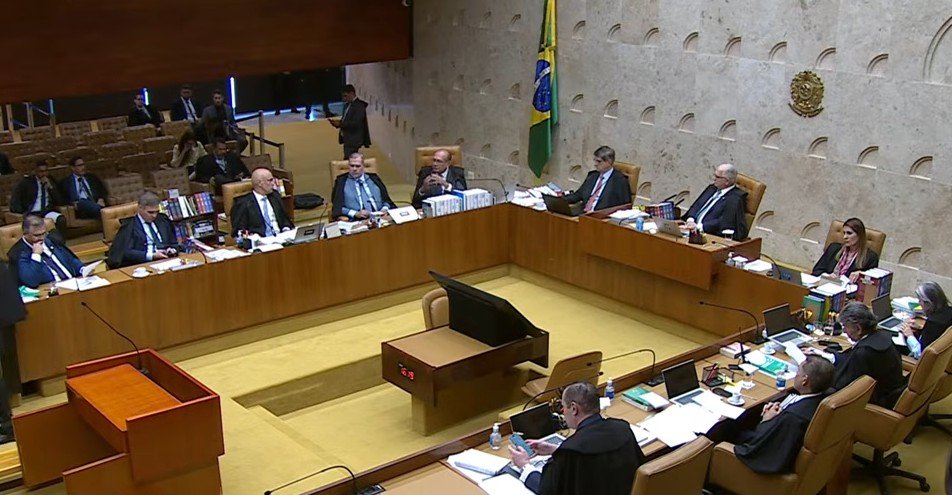 O que levou o STF a consolidar um regime de sigilo e decisões sem sorteio? O STF adotou medidas excepcionais em 2022, que se tornaram permanentes. A escolha de relatores por "conexão" e o aumento do segredo de justiça são centrais nesse novo modelo. Quais são as consequências do aumento do segredo de justiça no STF? O segredo de justiça crescente impede o acompanhamento público e afeta o debate público e a liberdade nas redes sociais, reduzindo a transparência e a responsabilização. Como a distribuição por conexão afeta a imparcialidade do STF? A distribuição por conexão elimina o sorteio eletrônico, concentrando processos em determinados ministros, o que compromete a imparcialidade e alimenta a crise de credibilidade. Por que o sigilo é considerado um problema no contexto atual do STF? O uso contínuo do sigilo retira a visibilidade de atos que definem o rumo do país, dificultando o acompanhamento da sociedade e a transparência das decisões judiciais. Qual foi o impacto das investigações de 8 de janeiro no volume de processos do STF? As investigações de 8 de janeiro aumentaram o volume total de processos, mascarando a proporção de casos sob sigilo, que havia crescido significativamente. Como o modelo atual do STF afeta a percepção pública sobre a instituição? O modelo atual, com decisões monocráticas e sigilo, gera desconfiança e questionamentos sobre a transparência e a imparcialidade do STF, afetando sua credibilidade. Quais são as críticas dos especialistas em relação ao novo modelo do STF? Especialistas criticam a falta de transparência e responsabilização, além do impacto negativo no debate público e na liberdade de expressão, devido ao excesso de sigilo. Como o novo modelo do STF se consolidou durante a disputa presidencial? Durante a última disputa presidencial, o STF adotou medidas excepcionais que, mesmo após o pleito, se tornaram práticas permanentes, consolidando o novo modelo. Qual é o papel do professor Ivar Hartmann no debate sobre o STF? O professor Ivar Hartmann, do Insper, realizou um levantamento que apoia a percepção de que o STF consolidou um modelo de atuação com menos transparência e mais sigilo. Como a sociedade pode acompanhar as decisões do STF sob o novo modelo? O acompanhamento das decisões do STF torna-se mais difícil devido ao sigilo, mas a sociedade pode buscar informações através de estudos e análises de especialistas. O que dizem os números sobre o aumento do sigilo nas decisões do STF? Em 2022, 36% das decisões em investigações criminais estavam sob sigilo. Esse número subiu para 46,2% nos primeiros meses de 2026, indicando uma tendência crescente. Qual é a opinião de Juliana Sakai sobre o excesso de segredo no STF? Juliana Sakai, da Transparência Brasil, alerta que o excesso de segredo impede o acompanhamento público, retirando a luz sobre atos que definem o rumo do país. Como o novo modelo do STF afeta a liberdade nas redes sociais? O ciclo de ordens monocráticas e o aumento do sigilo afetam diretamente a liberdade nas redes sociais, restringindo o debate público e a circulação de informações. Quais são as perspectivas futuras para o modelo de atuação do STF? O modelo atual do STF, com foco em sigilo e decisões sem sorteio, pode continuar gerando críticas e desconfiança, exigindo mudanças para aumentar a transparência e a confiança pública.
