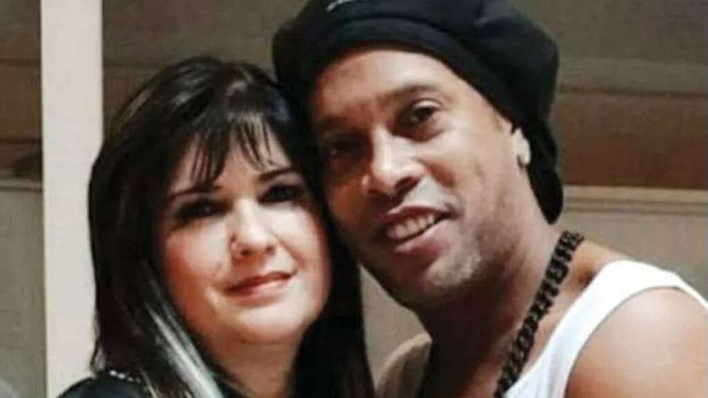 Quem é Dalia López e por que ela foi presa? Dalia López é uma empresária paraguaia, presa após seis anos foragida. Ela foi responsável por um evento que resultou na prisão de Ronaldinho Gaúcho e seu irmão no Paraguai, em 2020, por uso de documentos falsos. Como Dalia López foi capturada? Dalia foi presa em uma residência de luxo em Assunção. Quando a polícia chegou, ela estava com malas prontas para fugir novamente, mas não resistiu à prisão. Qual foi a reação das autoridades ao prender Dalia López? As autoridades ficaram surpresas com a quantia de dinheiro encontrada: 220 mil dólares e 300 milhões de guaranis, totalizando mais de R$ 1,3 milhão em espécie. Quem mais foi detido junto com Dalia López? Além de Dalia, um homem de 43 anos, identificado como parceiro, um motorista e uma funcionária doméstica foram detidos para averiguação. Qual foi o envolvimento de Ronaldinho Gaúcho no caso? Ronaldinho e seu irmão Assis foram presos no Paraguai ao tentarem entrar no país com passaportes falsos, após um evento organizado por Dalia López. Como Ronaldinho e Assis conseguiram retornar ao Brasil? Eles retornaram ao Brasil após quase um mês de detenção e meses em prisão domiciliar, mediante pagamento de multas pesadas. O que aconteceu com Dalia López após sua prisão? Ainda não há detalhes sobre as consequências legais imediatas para Dalia após sua prisão, mas sua captura encerra anos de fuga.