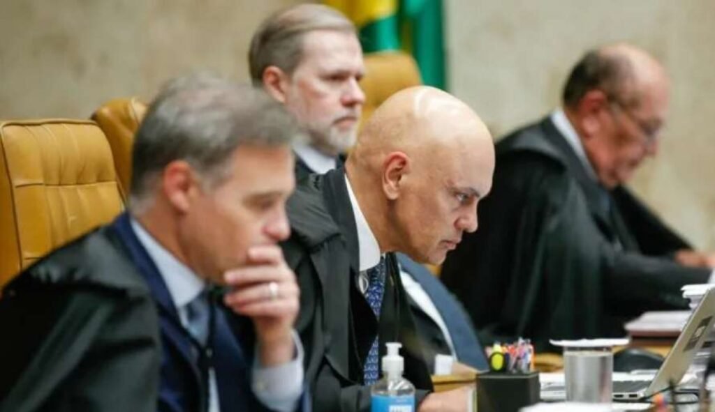 A avaliação que circula entre investigadores da **Polícia Federal** coloca **Alexandre de Moraes** em uma situação considerada mais sensível do que a de **Dias Toffoli** no **Caso Master**. Mas por que essa diferença chamou tanta atenção? Porque, segundo informação divulgada pela **CNN Brasil**, a leitura interna da apuração é de que os vínculos atribuídos a Toffoli e a Moraes têm naturezas distintas, e essa distinção muda o peso do cenário. Qual seria essa diferença? No caso de **Toffoli**, investigadores apontam que a relação com pessoas ligadas ao banqueiro **Daniel Vorcaro**, dono do **Banco Master**, teria caráter **comercial**, envolvendo negociações sobre parte do resort **Tayayá**. E o que isso significa para a investigação? Significa que, dentro dessa linha de análise, a conexão observada até aqui estaria associada a tratativas de negócio. E por que a situação de **Moraes** seria vista como mais delicada? Porque, de acordo com os relatos mencionados, haveria **indícios**, em tese, de uma atuação em benefício de interesses do empresário. Isso não encerra o caso, mas amplia a complexidade da apuração. E o que torna esse ponto ainda mais relevante? O fato de que, no ambiente da investigação, essa hipótese é tratada como mais sensível do que uma relação descrita apenas como comercial. Esse quadro levou a quais movimentações? Integrantes da investigação afirmam que haveria ações para evitar a abertura de um **inquérito** contra Moraes no próprio **Supremo Tribunal Federal**. Como isso poderia acontecer? Uma das estratégias citadas seria enfraquecer a posição do ministro **Kassio Nunes Marques**, apontado como peça importante em uma eventual deliberação do plenário. E por que **Nunes Marques** passou a ser visto como peça-chave? Porque, segundo a avaliação de membros da apuração, sua posição pode influenciar diretamente o resultado sobre a abertura de investigação contra Moraes. O que entrou nesse contexto? A informação de que **Kevin de Carvalho Marques**, filho de Nunes Marques, teria recebido **R$ 281,6 mil** da empresa **Consult Inteligência Tributária** entre **2024 e 2025**. Por que esse dado ganhou repercussão? Porque a mesma consultoria teria recebido **R$ 6,6 milhões** do **Banco Master** no mesmo período. E o que investigadores fazem com essa coincidência temporal e financeira? Passam a observá-la com atenção dentro do conjunto de elementos já reunidos. Há alguma consequência possível dessa observação? Sim. Entre membros da apuração, existe a avaliação de que, se **Nunes Marques** entender que ele ou seu filho se tornaram alvos, sua posição pode mudar. E essa eventual mudança teria impacto real? Teria, porque o cenário descrito por fontes que acompanham o caso aponta para uma **maioria apertada** no **STF** favorável à instauração do inquérito. Quem estaria nessa maioria? Segundo os relatos, **André Mendonça**, **Luiz Fux**, **Cármen Lúcia**, **Edson Fachin** e o próprio **Nunes Marques**. E quem ficaria no sentido contrário? A informação indica os ministros **Cristiano Zanin**, **Dias Toffoli**, **Flávio Dino** e **Gilmar Mendes**. Onde entra **Moraes** nessa conta? Como eventual investigado, ele **não participaria da votação**. Mas o STF pode abrir uma investigação contra um de seus próprios ministros sem etapa prévia? Não. Pelas **normas internas do STF**, qualquer investigação envolvendo um ministro da Corte depende de **autorização do plenário**. E, se o inquérito for aberto, o processo segue automaticamente? Também não. A continuidade dependerá de manifestação do **procurador-geral da República, Paulo Gonet**. Isso significa que a abertura do inquérito garante uma denúncia? Não. Investigadores ouvidos pela **CNN Brasil** consideram **incerta** a possibilidade de uma denúncia formal contra integrantes do Supremo. Por quê? Porque, segundo essa avaliação, a proximidade de **Gonet** com ministros da Corte é vista como um fator relevante nesse cálculo. Então, o que está posto até aqui? Que, no âmbito das investigações sobre o **Banco Master**, a leitura predominante entre investigadores da **PF** é a de que **Alexandre de Moraes** enfrenta hoje uma situação mais sensível do que **Dias Toffoli**; que haveria movimentações para evitar a abertura de um inquérito no **STF**; que **Kassio Nunes Marques** aparece como voto decisivo nesse cenário; que o nome de seu filho, **Kevin de Carvalho Marques**, entrou no radar após o recebimento de **R$ 281,6 mil** da **Consult Inteligência Tributária** entre **2024 e 2025**; que essa empresa recebeu **R$ 6,6 milhões** do **Banco Master** no mesmo intervalo; e que a eventual abertura da investigação dependerá primeiro do **plenário do STF** e, depois, de manifestação do **procurador-geral da República, Paulo Gonet**.