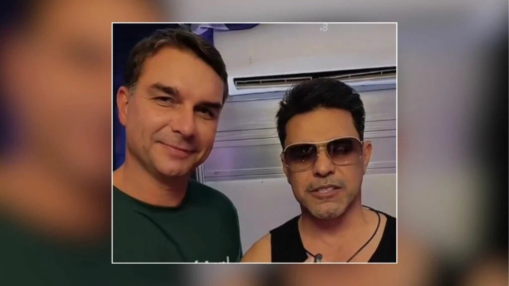 Bastou um vídeo curto para acender uma pergunta que muita gente quis responder até o fim: o que, afinal, Zezé Di Camargo disse ao encontrar Flávio Bolsonaro? A dúvida cresceu porque não foi apenas um registro casual, desses que aparecem e somem nas redes. Havia um recado direto, uma fala carregada de apoio e um destinatário que muda completamente o peso da cena. Mas antes de chegar ao centro da mensagem, vale entender por que esse encontro chamou tanta atenção. Foi só uma foto entre conhecidos? Não exatamente. O momento foi gravado, publicado e compartilhado com destaque, o que transformou um encontro público em sinal político e emocional ao mesmo tempo. E quando isso acontece, a curiosidade deixa de ser sobre a imagem e passa a ser sobre o conteúdo. Mas quem estava com quem, e em que circunstância isso aconteceu? A resposta começa por Flávio Bolsonaro, senador e pré-candidato ao Planalto, que esteve em um evento importante na noite de quinta-feira, dia 9. Foi ali que ele encontrou Zezé Di Camargo e decidiu registrar a conversa em vídeo. Só que o que parecia ser apenas mais uma gravação de bastidor ganhou outro tamanho quando o cantor direcionou suas palavras a Jair Bolsonaro. E o que foi dito de tão relevante? Zezé começou destacando a importância do ex-presidente. Disse que Jair Bolsonaro deve ter noção disso, mas reforçou o quanto ele é importante para o povo do Brasil. A fala não parou aí. O cantor afirmou que vê o quanto Bolsonaro é amado pelas pessoas, “verdadeiramente”. E então veio a parte que mais repercutiu: “independente das circunstâncias, a gente está com você”. Mas há um ponto que quase passa despercebido nesse tipo de vídeo: por que uma mensagem assim repercute tanto? Porque ela não surge isolada. Quando uma figura popular como Zezé Di Camargo faz uma declaração pública de apoio, o gesto ultrapassa o campo pessoal. Ele vira sinal, posicionamento e combustível para debate. E é justamente aí que muita gente se surpreende: não foi apenas um cumprimento, foi uma demonstração explícita de carinho e alinhamento. E Flávio, como reagiu? Depois de publicar o encontro, ele elogiou Zezé nas redes sociais. Disse que não é à toa que o cantor é um dos maiores do Brasil, agradeceu pelo carinho e desejou que Deus siga abençoando sua vida. A resposta ajudou a ampliar ainda mais o alcance do momento, porque reforçou que o vídeo não era um detalhe secundário da agenda, mas algo que merecia destaque. Só que o contexto ainda guardava outra camada. Onde tudo isso aconteceu? Na 86ª edição da Expogrande, em Campo Grande, capital de Mato Grosso do Sul. E esse detalhe muda a leitura porque mostra que o encontro ocorreu em um evento de grande visibilidade, com presença de nomes importantes da política local e nacional. Quem mais apareceu depois da gravação? Flávio e Zezé posaram para fotos ao lado do governador de Mato Grosso do Sul, Eduardo Riedel, da primeira-dama Mônica Riedel, do ex-governador Reinaldo Azambuja, do presidente da Acrissul, Guilherme Bumlai, e do deputado federal Rodolfo Nogueira. O que acontece depois desse tipo de registro também pesa: a imagem deixa de ser apenas um vídeo e passa a compor um cenário político mais amplo. Mas a pergunta que fica no ar é outra: por que esse encontro continua chamando atenção mesmo depois da publicação? Porque ele reúne três elementos que raramente passam despercebidos quando aparecem juntos: um artista de enorme alcance popular, um senador em movimento político e uma mensagem direta ao ex-presidente Jair Bolsonaro. Quando esses pontos se cruzam, o episódio deixa de ser simples e passa a ter leitura pública imediata. No fim, o principal recado foi claro: Zezé Di Camargo aproveitou o encontro com Flávio para declarar apoio e carinho a Jair Bolsonaro diante das câmeras. Só que o detalhe mais interessante talvez não esteja apenas no que foi dito, mas no peso de ter sido dito ali, daquela forma, e no momento em que foi registrado. E é justamente isso que mantém a cena aberta, mesmo depois que o vídeo termina.