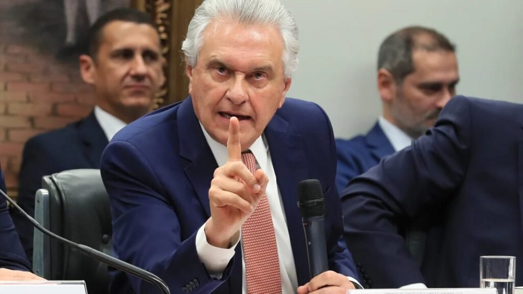 Ronaldo Caiado, ex-governador de Goiás e pré-candidato à Presidência pelo PSD, decidiu comprar a briga a favor das urnas eletrônicas e contra qualquer questionamento vindo de fora. Depois de o governo brasileiro negar visto a dois representantes do Departamento de Estado dos EUA, que viriam tratar da integridade do sistema eleitoral, Caiado apareceu para dizer que confia totalmente nas urnas e que é “inadmissível” qualquer país – inclusive os Estados Unidos – colocar em dúvida a lisura das eleições brasileiras. Ou seja: enquanto parte da direita há anos pede auditoria séria, transparência real e possibilidade de fiscalização independente, Caiado se posiciona exatamente onde a esquerda e o TSE sempre quiseram todo mundo: na linha do “não pode questionar”. Quem ganha com isso? Por que conservador repete discurso oficial? Porque, na prática, ao chamar de “inadmissível” qualquer dúvida externa, Caiado reforça a ideia de que o sistema é intocável e que questionar virou quase pecado político. Por que questionar urnas virou tabu? Porque a narrativa dominante transformou qualquer crítica em “ataque à democracia”, criando um escudo perfeito para o TSE e para quem está no poder. Por que EUA agora são problema? Porque, quando interessa, o mesmo establishment que vive de acenar para Washington usa o rótulo de “interferência estrangeira” para blindar o que não quer que seja investigado. Por que esquerda aplaude essa fala? Porque é exatamente o que ela sempre defendeu: confiança cega nas urnas, sem espaço para auditoria robusta, sem debate público profundo e sem contestação séria. Por que TSE segue sempre blindado? Porque, com políticos de todos os lados repetindo que “confiam plenamente” e que é “inadmissível” duvidar, o tribunal fica acima de qualquer suspeita prática, mesmo sendo um órgão de Estado que deveria prestar contas. Por que observador pode, fiscal não pode? Porque observador internacional serve como selo simbólico, enquanto fiscalização técnica e independente poderia expor falhas, inconsistências ou, no mínimo, exigir mudanças estruturais. Por que governo barrou visita americana? Porque diplomatas viram na agenda um movimento incomum e temeram que qualquer conversa sobre integridade eleitoral abrisse brecha para questionamentos sobre a legitimidade das urnas. Por que direita fica isolada nisso? Porque quem ainda levanta dúvidas sobre o sistema é tratado como radical, enquanto figuras que buscam “respeitabilidade” em Brasília correm para mostrar alinhamento com o discurso oficial. Por que sempre falta transparência completa? Porque, se houvesse abertura total de código, auditoria independente ampla e mecanismos claros de conferência pública, a discussão mudaria de narrativa para fatos – e isso muita gente não quer. Por que conservador não pode perguntar mais? Porque o ambiente foi moldado para que qualquer pergunta sobre segurança, rastreabilidade ou auditoria das urnas seja vista como ameaça, e não como exercício legítimo de cidadania. Caiado diz que confia nas urnas e que aceita observadores internacionais, mas rejeita que qualquer país ouse levantar dúvida sobre o resultado. O governo brasileiro, por sua vez, nega visto a dois indicados politicamente pela gestão Trump, alegando interferência. O Departamento de Estado reage, chama de “mentira sem fundamento” a versão de que queria enfraquecer o processo eleitoral e diz que a visita seria rotineira. No meio disso tudo, o TSE admite que recebeu uma consulta da Embaixada dos EUA, mas diz que nem chegou a marcar a visita por causa do recesso. O Itamaraty fala em “caráter incomum” e fecha a porta. Resultado: ninguém toca no ponto central – transparência total do sistema – mas todo mundo corre para defender a narrativa que mais convém. Enquanto a esquerda comemora mais um aliado na defesa incondicional das urnas, o eleitor conservador olha e se pergunta: quem, afinal, vai ter coragem de defender transparência de verdade, sem medo de desagradar o sistema?
