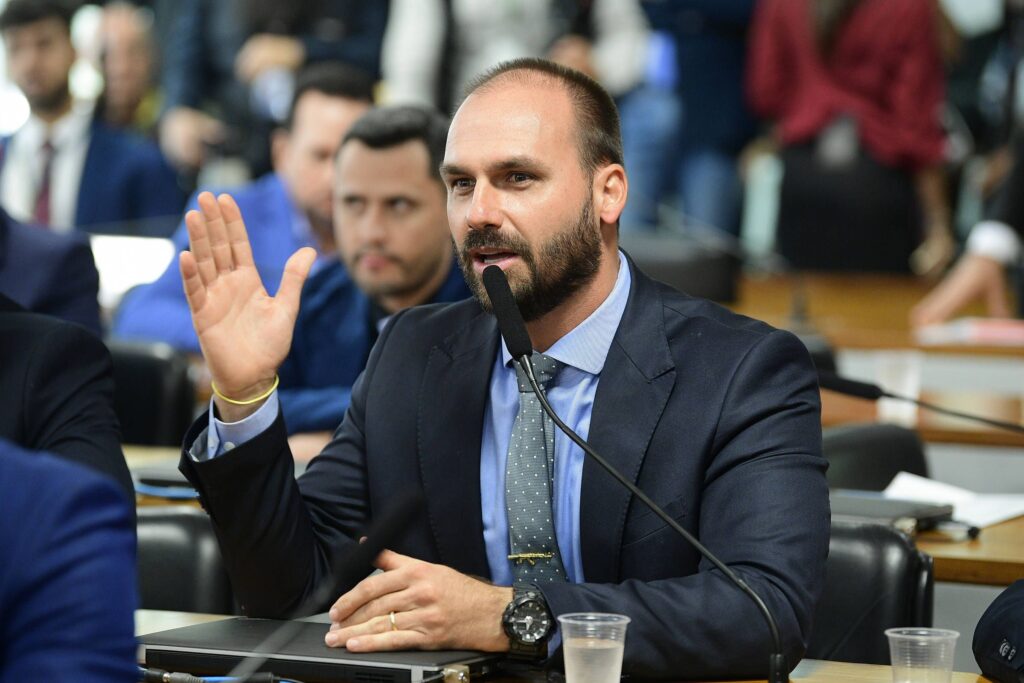 Quem acompanha a política brasileira já percebeu que, quando o alvo é alguém ligado à direita, o sistema não alivia. Enquanto figuras da esquerda seguem blindadas, com processos engavetados e patrimônio intocado, qualquer movimento de um Bolsonaro vira espetáculo, manchete e motivo para nova rodada de pressão. Agora, o foco é em cima de Eduardo Bolsonaro. Não basta condenação no STF, não basta o processo ligado ao 8 de Janeiro, não basta a narrativa de sempre tentando colar nele a imagem de inimigo da democracia. A ofensiva avança também para o lado financeiro, atingindo diretamente o patrimônio que ele construiu. Por que só um lado paga caro? Porque a reação do sistema é seletiva, e a esquerda sabe disso. Quando é petista ou aliado, fala-se em diálogo, conciliação, reconstrução. Quando é alguém da família Bolsonaro, a palavra é punição exemplar. Qual é o alvo real aqui? O alvo é enfraquecer politicamente quem representa a oposição conservadora, desgastar a imagem pública e mandar um recado para qualquer um que ouse enfrentar o establishment. Por que o leilão chama atenção? Porque envolve um apartamento em área nobre do Rio, comprado em 2017, financiado pela Caixa e hoje colocado em leilão com grande desconto, ao mesmo tempo em que o imóvel já aparece bloqueado por ordem de Alexandre de Moraes no processo do 8 de Janeiro. Isso é só cobrança bancária? Não. É mais um capítulo de um contexto em que decisões judiciais, bloqueios e condenações se acumulam sempre no mesmo lado do espectro político, enquanto escândalos milionários da esquerda somem do noticiário. Até onde isso vai chegar? A situação mostra que o cerco contra a direita conservadora não é teoria da conspiração, é realidade documentada: condenação no STF, bloqueio judicial e agora leilão de imóvel, tudo em cima do filho do ex-presidente que mais enfrentou o sistema. No fim, o fato é simples e simbólico: o apartamento de Eduardo Bolsonaro em Botafogo, avaliado em cerca de 1 milhão de reais, foi tomado pela Caixa e colocado em leilão com desconto pesado, em meio a bloqueio determinado por Moraes e a uma condenação unânime no STF. Para muitos brasileiros, fica a sensação de que, quando o alvo é a direita, não existe limite para o cerco.
