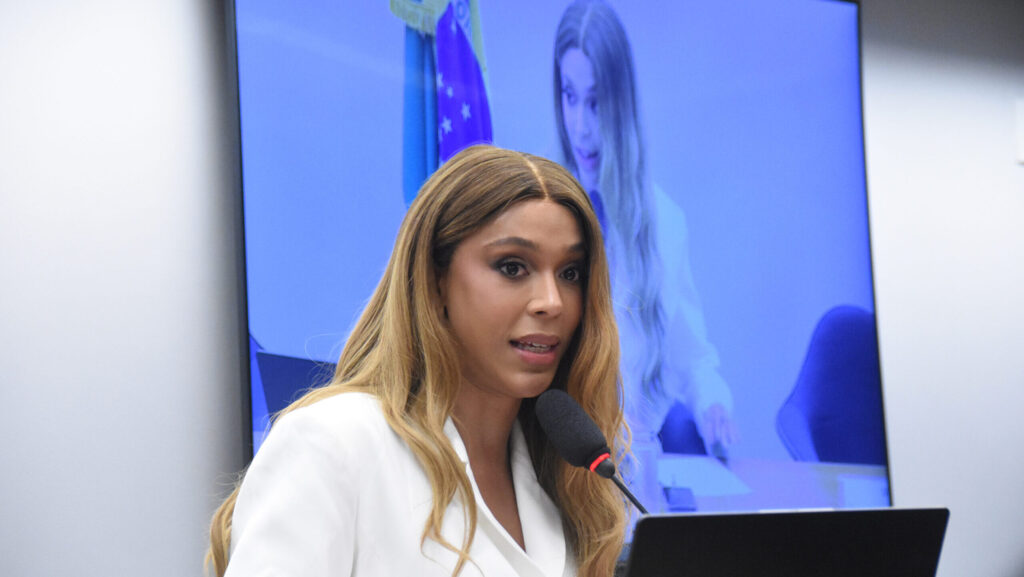 Há anos a esquerda vende a imagem de Erika Hilton como símbolo perfeito do “novo jeito” de fazer política, sempre cercada de holofotes, entrevistas e campanhas emocionadas nas redes sociais. Enquanto isso, o brasileiro comum segue atolado em impostos, reforma tributária confusa e promessas de justiça social que nunca chegam na vida real. Agora, em pleno ano eleitoral, um detalhe incômodo escapa da bolha progressista: a crítica não veio da direita, não veio de “bolsonarista radical”, veio de dentro do próprio PSOL, de quem trabalhou diretamente com ela na Câmara. Por que isso incomoda tanto? Porque desmonta a narrativa de que basta lacrar na internet para ser grande parlamentar. Segundo o economista David Deccache, ex-assessor da bancada do PSOL, durante a segunda fase da reforma tributária ele era o responsável pela pauta e simplesmente não discutiu o tema com a então líder Erika Hilton. Nenhuma palavra. Nenhuma conversa técnica. Nada. Enquanto o país era redesenhado nos bastidores, a liderança, segundo ele, demonstrava “total descaso” e se comportava como “uma verdadeira diva pop”, inacessível. Quem realmente comandava a liderança? Outros parlamentares acabaram assumindo tarefas que deveriam ser dela, de acordo com o ex-assessor. A crítica vai além: na votação que reduziu o alcance do abono salarial, benefício justamente para quem a esquerda diz defender, Deccache afirma que Erika “não fez absolutamente nada” para tentar reverter. Onde estava toda a indignação social que aparece nos discursos e nas redes? Por que a esquerda silencia agora? Porque é um aliado expondo a contradição entre o discurso social e a prática parlamentar. Ao mesmo tempo, a declaração de patrimônio baixíssimo, contrastando com bolsas de até 25 mil reais e roupas de grife, já vinha gerando desconfiança nas redes. A resposta dela foi apelar para o vitimismo, dizendo que não enriquece porque ajuda a família e tem “bom gosto pra se vestir”. No fim, fica a pergunta que muitos conservadores repetem: até quando o Brasil vai aceitar político de esquerda que brilha como influencer, posa de vítima, fala em nome dos pobres, mas é acusado até por ex-assessor de ser péssimo como parlamentar justamente onde mais importa, nos bastidores do Congresso?