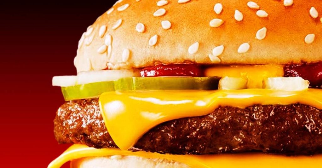 Pouca gente percebe, mas o famoso Quarterão com Queijo do McDonald’s nasceu como um truque de marketing em cima de uma medida que quase ninguém no Brasil entende. O lanche foi criado em 1971, nos Estados Unidos, para vender a ideia de “mais carne” usando um nome técnico e chamativo: um quarto de libra de carne bovina antes de ir para a chapa. Por que isso importa hoje? Porque o nome virou verdade absoluta na cabeça do consumidor, mas quase ninguém sabe o que realmente está por trás dele. Quem criou o Quarterão com Queijo? Um franqueado americano chamado Al Bernardin. Quanto pesa a carne do Quarterão? Cerca de 113 gramas antes do cozimento. O que significa “quarterão” no Brasil? Aqui, lembra quarteirão de rua, não peso. Por que usaram libra, não gramas? Porque nos EUA libra é medida comum e vende “tamanho”. Quando o lanche chegou ao Brasil, a rede simplesmente adaptou o nome para “Quarterão com Queijo”, tirou o “i” de quarteirão e deixou o consumidor que se virasse para entender. Nada de explicar que aquilo era uma fração de uma unidade de massa estrangeira. Só jogaram o nome e pronto. Por que o nome causa tanta confusão? Porque em português “quarteirão” remete a quadra de cidade, não a peso. A tradução ficou no meio do caminho: não é inglês, não é português claro, e ainda esconde a informação principal — a quantidade de carne. Outros países foram mais diretos? Sim. França, Portugal, Espanha e até Hong Kong adaptaram o nome para algo que a população entende melhor. Como a França chama o lanche? Lá virou “Royal Cheese”, fugindo da medida em libra. E em Portugal, qual o nome? “McRoyal Cheese”, também sem libra no título. Na Espanha, o que fizeram? Foram literais: “Cuarto de Libra con Queso”. O caso mais curioso é Hong Kong. Lá, o McDonald’s traduziu o conceito para a medida local: chamou o lanche de “três taels completos”, usando a unidade tradicional de massa do país. Ou seja, mantiveram a ideia de “peso da carne”, mas falaram a língua do povo. Por que Hong Kong mudou o nome? Para usar uma unidade que o público realmente conhece. O Brasil fez o quê? Aceitou um nome híbrido, meio inglês, meio português, que não explica nada. Isso engana o consumidor brasileiro? Enganar é forte, mas certamente não ajuda a informar. O ponto é simples: enquanto outros países se preocuparam em traduzir o conceito de forma clara, aqui ficou tudo nebuloso. O lanche virou tradição, o nome pegou, e ninguém mais questiona. A marca agradece: vende a sensação de “lanche maior” sem precisar explicar muito. Por que o marketing escolheu esse caminho? Porque “um quarto de libra” soa técnico, robusto e diferente. O peso ainda é o mesmo hoje? A referência original é de 113 gramas antes do cozimento. No fim, o Quarterão com Queijo é o retrato perfeito de como grandes marcas jogam com linguagem, costume e falta de informação. Um detalhe técnico vira rótulo poderoso, atravessa fronteiras, muda de nome em cada país e, no Brasil, continua soando importante sem que a maioria saiba exatamente o que está comprando. Até quando vamos aceitar nomes bonitos sem entender o que significam? Enquanto ninguém perguntar, o marketing continua mandando no cardápio – e na nossa percepção.
