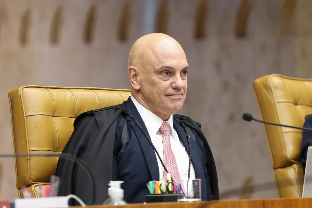 Alexandre de Moraes decidiu colocar a Lei Antifacção no banco dos réus bem no momento em que o país pede mais rigor contra o crime organizado. O ministro do STF convocou audiência pública para discutir quatro ações que atacam o novo Marco Legal do Combate ao Crime Organizado, justamente a lei que endurece penas, restringe benefícios e tenta sufocar o poder das facções. Quem esperava um Supremo alinhado ao clamor por segurança vê, de novo, o roteiro conhecido: quando a lei aperta o cerco contra o crime, surgem “especialistas” e entidades para dizer que é tudo inconstitucional, que fere garantias, que é exagero. E, claro, o STF abre as portas. Por que atacar a Lei Antifacção agora? Porque as ações alegam que vários pontos da lei violam garantias fundamentais, e Moraes decidiu ouvir especialistas antes de julgar. A audiência será nos dias 24 e 25 de agosto, no plenário do STF. Em debate, pontos centrais da lei: criação de novos crimes e aumento de penas para chefes de organizações criminosas, proibição de livramento condicional, presunção de necessidade de prisão preventiva e até perdimento de bens sem condenação penal. Quem ganha com esse questionamento todo? Na prática, quem é alvo da lei: lideranças do crime organizado e estruturas que lucram com o caos. Também estão na mira regras que permitem medidas cautelares contra empresas ligadas ao crime, monitoramento de encontros entre advogados e presos, cancelamento de título de eleitor de condenados por certos crimes e realização de audiências de custódia por videoconferência. Esses pontos incomodam quem exatamente? Incomodam quem sempre usou brechas processuais, visitas “técnicas” e formalidades para manter o sistema funcionando a favor do crime. Moraes justificou a audiência dizendo que o tema é relevante para a ordem social e a segurança jurídica. Mas a pergunta que o brasileiro faz é outra: por que a mesma pressa e o mesmo rigor vistos contra a direita nunca aparecem quando o alvo é o crime organizado e o sistema que o alimenta? Onde está a coerência do Supremo? Ela some quando o discurso de “garantias” pesa mais que a proteção do cidadão comum. A Lei Antifacção tenta corrigir anos de leniência com facções que mandam em presídios, bairros e até em eleições locais. Aumentar penas para chefes de organizações criminosas e dificultar benefícios não é “autoritarismo”; é o mínimo para um país que já vive sob o medo diário. Por que tanto medo de endurecer leis? Porque parte da elite jurídica ainda trata criminoso perigoso como vítima do sistema, não como ameaça real. As entidades interessadas em falar na audiência poderão se inscrever até o dia 10. Serão escolhidas por critérios como “pluralidade de opiniões” e “especialização técnica”. Traduzindo: o palco perfeito para o velho coro garantista que sempre aparece quando o Estado tenta reagir. Quem vai defender o cidadão nessa audiência? Provavelmente poucos: a maioria será de vozes preocupadas com o réu, não com a vítima. Enquanto isso, o recado para o brasileiro é claro: quando o Congresso aprova uma lei dura contra facções, nada está garantido. Tudo pode ser reescrito no plenário do STF, em nome de uma interpretação “superior” da Constituição. O que acontece se a lei for esvaziada? O combate ao crime organizado perde força, e a sensação de impunidade aumenta ainda mais. A ironia é inevitável: o mesmo sistema que se diz “em defesa da democracia” hesita em apoiar uma lei que atinge diretamente organizações que desafiam o Estado todos os dias. Facções que controlam territórios, impõem toque de recolher e executam quem desobedece parecem ter mais defensores técnicos do que o cidadão honesto que só quer viver em paz. Por que o brasileiro está cansado disso? Porque vê um abismo entre o discurso de proteção à sociedade e as decisões que, na prática, favorecem o crime. Moraes ainda convidou os demais ministros e o procurador-geral da República para a audiência. Tudo muito formal, muito técnico, muito “plural”. Mas a pergunta que não cala é simples: quem está disposto a bancar, até o fim, uma lei realmente dura contra o crime organizado? Quem vai assumir o custo político da firmeza? Se o STF recuar, o recado para as facções será de alívio, não de medo. O Brasil entra em mais um capítulo decisivo: ou a Lei Antifacção se mantém forte, ou veremos, de novo, a velha história de sempre – quando a lei aperta o bandido, o sistema corre para afrouxar. E o cidadão, mais uma vez, fica sozinho na linha de frente. O que o povo pode esperar agora? Um julgamento que mostrará se o STF está ao lado da segurança ou da velha agenda garantista que já falhou com o Brasil.