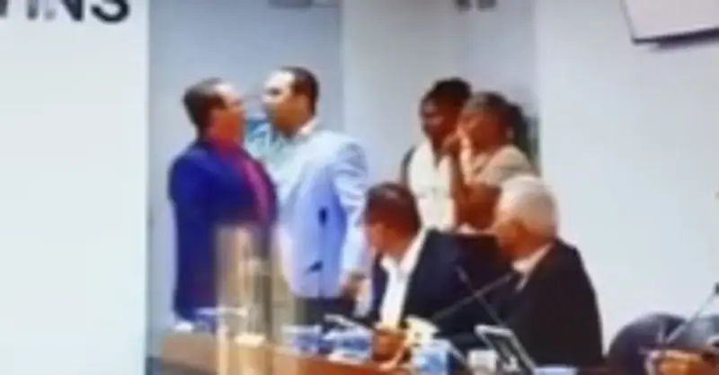 Logo na reabertura dos trabalhos, a Câmara Municipal de Riachão do Jacuípe, na Bahia, virou palco de pancadaria entre vereadores e teve a sessão suspensa. Em vez de discutir problemas da cidade, Joquinha (PSD) e João Igor (União) partiram para a agressão física, trocaram socos em pleno plenário e obrigaram colegas a separar a briga. Como começou a confusão? Os dois se esbarraram quando João Igor, vice-presidente, deixava a Mesa Diretora e seguia para a saída, enquanto Joquinha entrava no plenário. O que deveria ser apenas a retomada do semestre legislativo virou cena de caos, com gritaria, empurra-empurra e a Polícia Militar chamada às pressas. Quem são os vereadores envolvidos? São dois parlamentares locais: Joquinha, do PSD, e João Igor, do União Brasil, vice-presidente da Câmara. Ambos representam grupos políticos que deveriam estar focados em fiscalizar o Executivo e propor soluções para a população, mas acabaram protagonizando um espetáculo de descontrole. Por que a sessão foi suspensa? Porque a troca de socos inviabilizou qualquer continuidade dos trabalhos. O presidente da Câmara, Franklin Santana (União), não teve alternativa a não ser suspender temporariamente a sessão, que só foi retomada cerca de duas horas depois, quando a confusão já havia sido contida. O que a Câmara disse oficialmente? Em nota, a Câmara classificou a briga como um “desentendimento pontual” e tentou minimizar o episódio, falando em compromisso com respeito, diálogo e convivência democrática. Para quem viu a cena de pancadaria, a nota soa como puro faz de conta institucional. Por que chamaram a Polícia Militar? Porque a situação saiu completamente do controle. Quando dois vereadores partem para a agressão física dentro do plenário, a segurança interna não dá conta, e a PM é acionada para evitar algo ainda pior. Mesmo assim, não houve prisões, o que levanta questionamentos sobre a real consequência prática para os envolvidos. Isso é comum em câmaras municipais? Infelizmente, cenas de baixaria, gritaria e até agressões físicas não são raras em câmaras pelo Brasil. O caso da Bahia apenas expõe, mais uma vez, como parte da classe política trata o espaço público como arena pessoal, enquanto a população segue sem respostas para problemas básicos. Os vereadores serão punidos de verdade? A Presidência da Casa prometeu enquadrar os dois nos termos do Regimento Interno, para garantir o decoro parlamentar e a harmonia institucional. Na prática, a dúvida é se isso vai passar de advertência formal e discurso bonito, sem qualquer punição exemplar. Por que isso revolta tanta gente? Porque o brasileiro está cansado de ver políticos que ganham salários altos, têm estrutura paga pelo contribuinte e, em vez de trabalhar, transformam o plenário em ringue. Enquanto isso, saúde, educação, segurança e infraestrutura seguem com problemas crônicos. Agora, as perguntas que muitos leitores fazem ao ver essa cena: Por que vereadores partiram para agressão? Porque houve um desentendimento pessoal e político no momento em que se esbarraram na entrada e saída do plenário, revelando falta total de controle emocional e respeito ao cargo. Qual foi o papel da polícia? A Polícia Militar foi chamada para conter a confusão, garantir a segurança no local e evitar que a briga se agravasse, embora não tenha efetuado prisões após o episódio. Houve algum ferido na pancadaria? A notícia não relata feridos graves, apenas a troca de socos e o tumulto generalizado, o que já é suficiente para caracterizar quebra de decoro e desrespeito ao ambiente legislativo. A sessão realmente foi retomada depois? Sim, a sessão foi reiniciada no fim da manhã, cerca de duas horas após a suspensão, quando a situação já estava controlada e os ânimos aparentemente mais calmos. O presidente da Câmara se posicionou? Sim, Franklin Santana determinou a suspensão temporária dos trabalhos e, em nota oficial, lamentou o ocorrido, prometendo enquadrar os envolvidos conforme o Regimento Interno da Casa. O que significa ‘desentendimento pontual’ exatamente? É a forma branda que a Câmara usou para tentar minimizar a gravidade da briga, tratando uma troca de socos em plenário como se fosse apenas um pequeno conflito isolado. A população pode cobrar punições sérias? Sim, moradores podem pressionar a Câmara, participar das sessões, usar redes sociais e cobrar transparência sobre o processo disciplinar, exigindo que o caso não seja varrido para debaixo do tapete. Esse caso afeta a imagem da política? Afeta diretamente, porque reforça a percepção de que muitos políticos não respeitam o cargo, não têm preparo emocional e usam o espaço público para disputas pessoais, afastando ainda mais o cidadão da vida política. Há risco de novos confrontos futuros? Se não houver punição clara e exemplo firme, o recado interno pode ser de impunidade, o que aumenta o risco de novos episódios de desrespeito e até violência entre parlamentares. O regimento interno será realmente aplicado? A Câmara afirma que sim, mas a sociedade precisa acompanhar de perto, pois, sem pressão popular, casos assim costumam terminar em advertências leves e esquecimento rápido. Enquanto a nota oficial fala em “convivência democrática”, o que se viu foi exatamente o contrário: vereadores que não conseguem nem ouvir um “bom dia” sem transformar o plenário em ringue. E o contribuinte, mais uma vez, paga a conta desse espetáculo lamentável.